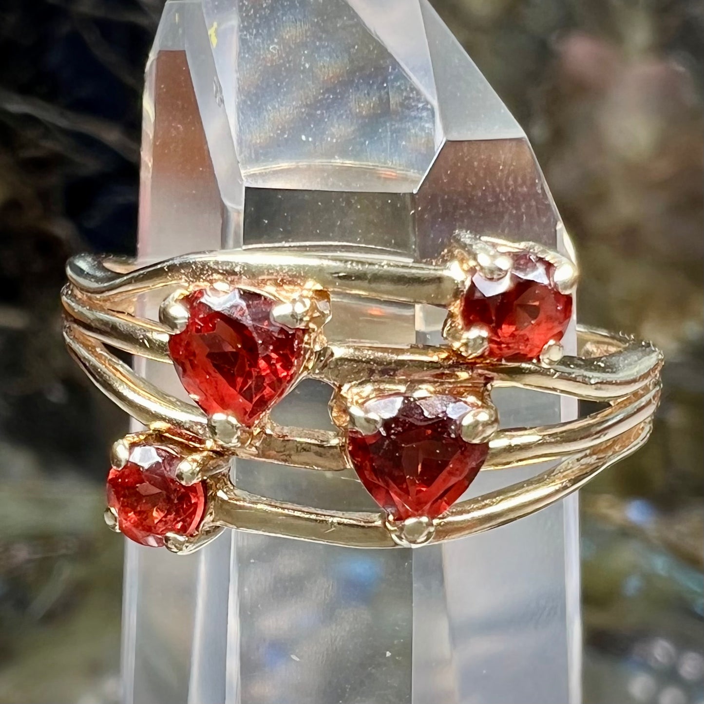 A yellow gold multishank ring set with two heart shape and two round cut red garnets.