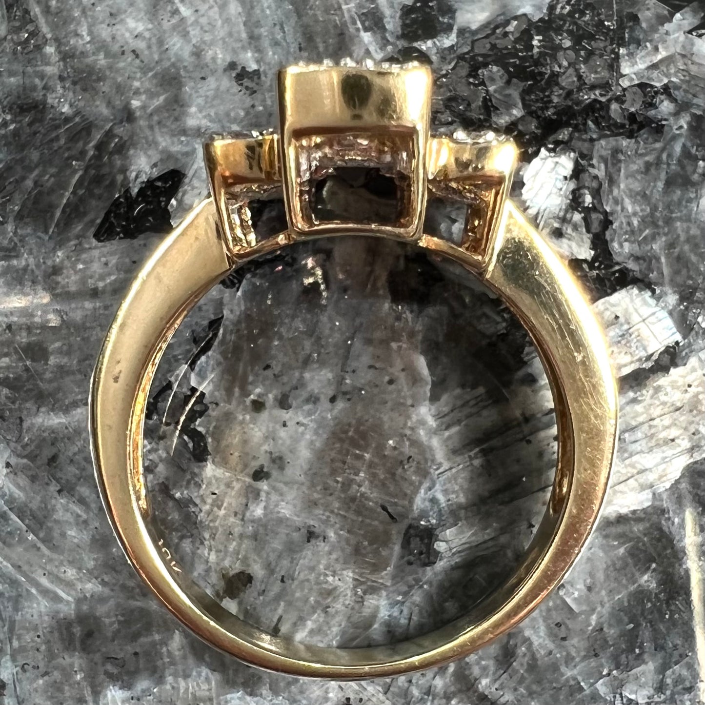 An Art Deco style emerald cut garnet and diamond ring cast in yellow gold.