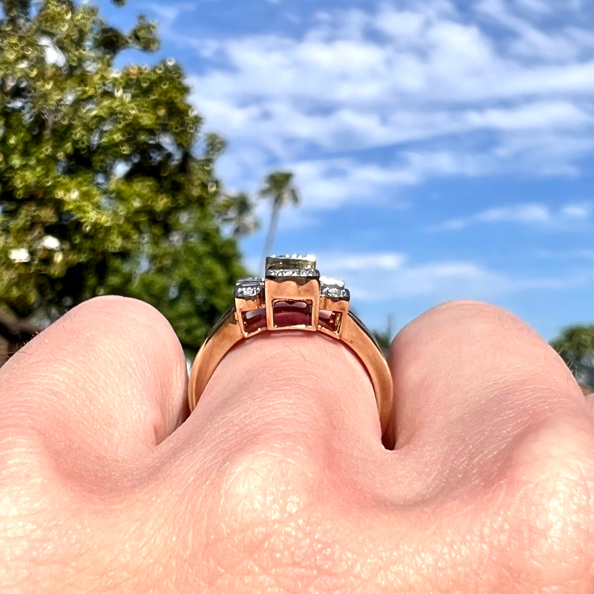 An Art Deco style emerald cut garnet and diamond ring cast in yellow gold.
