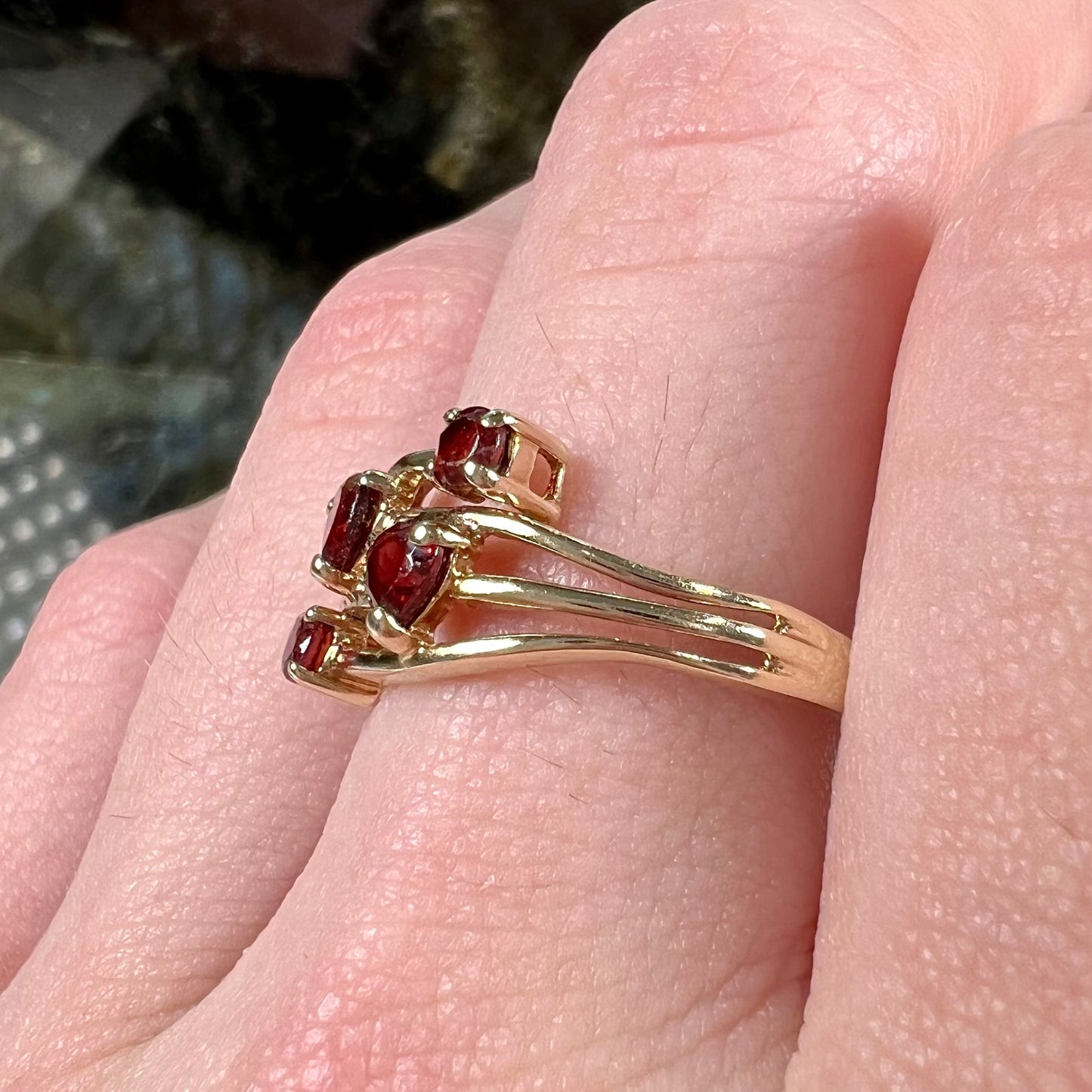 A yellow gold multishank ring set with two heart shape and two round cut red garnets.