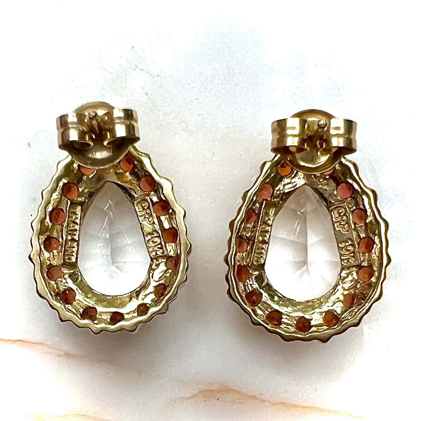 Pear shape white topaz and garnet halo stud earrings in yellow gold.