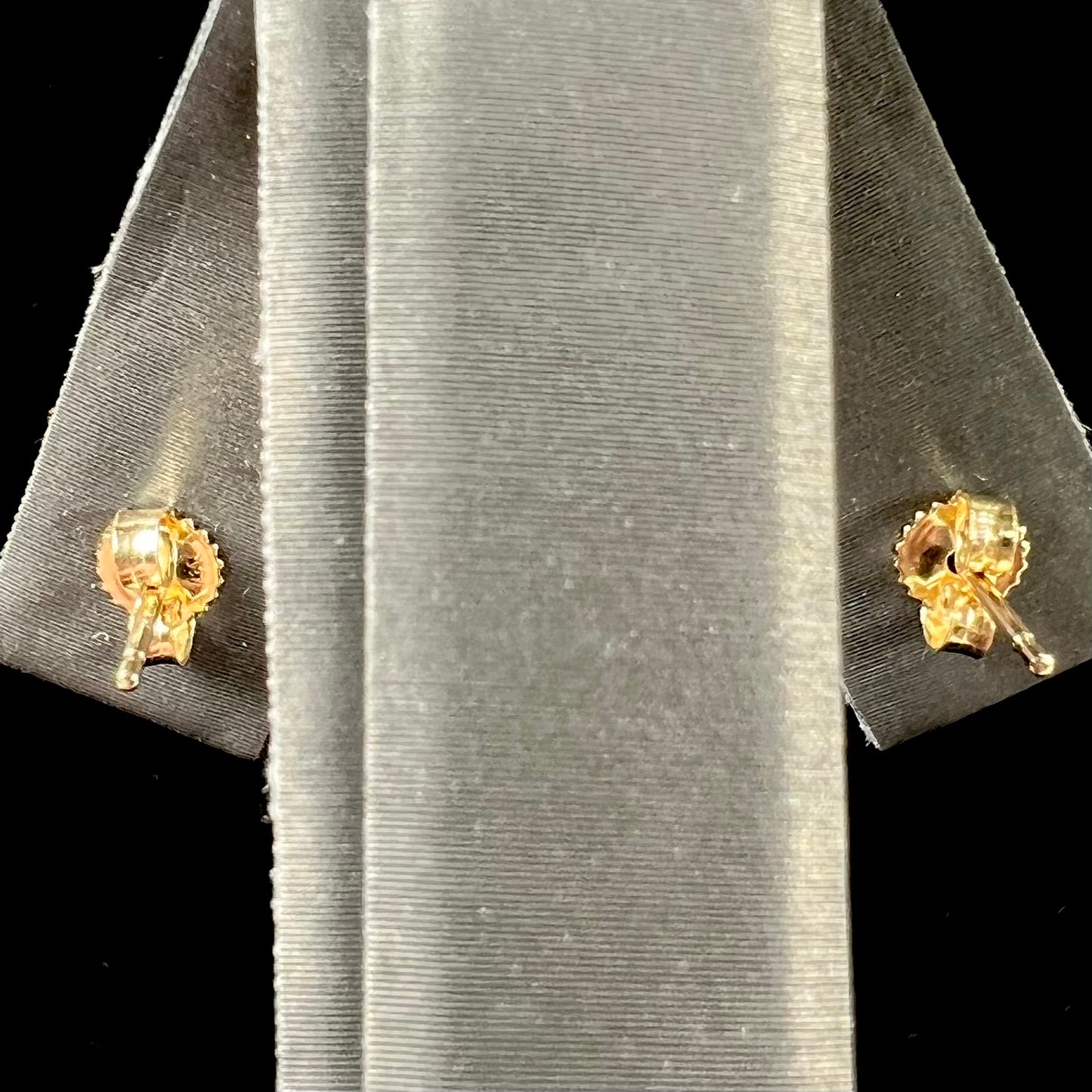 A pair of yellow gold orange hessonite garnet stud earrings. The garnets are faceted oval cut.