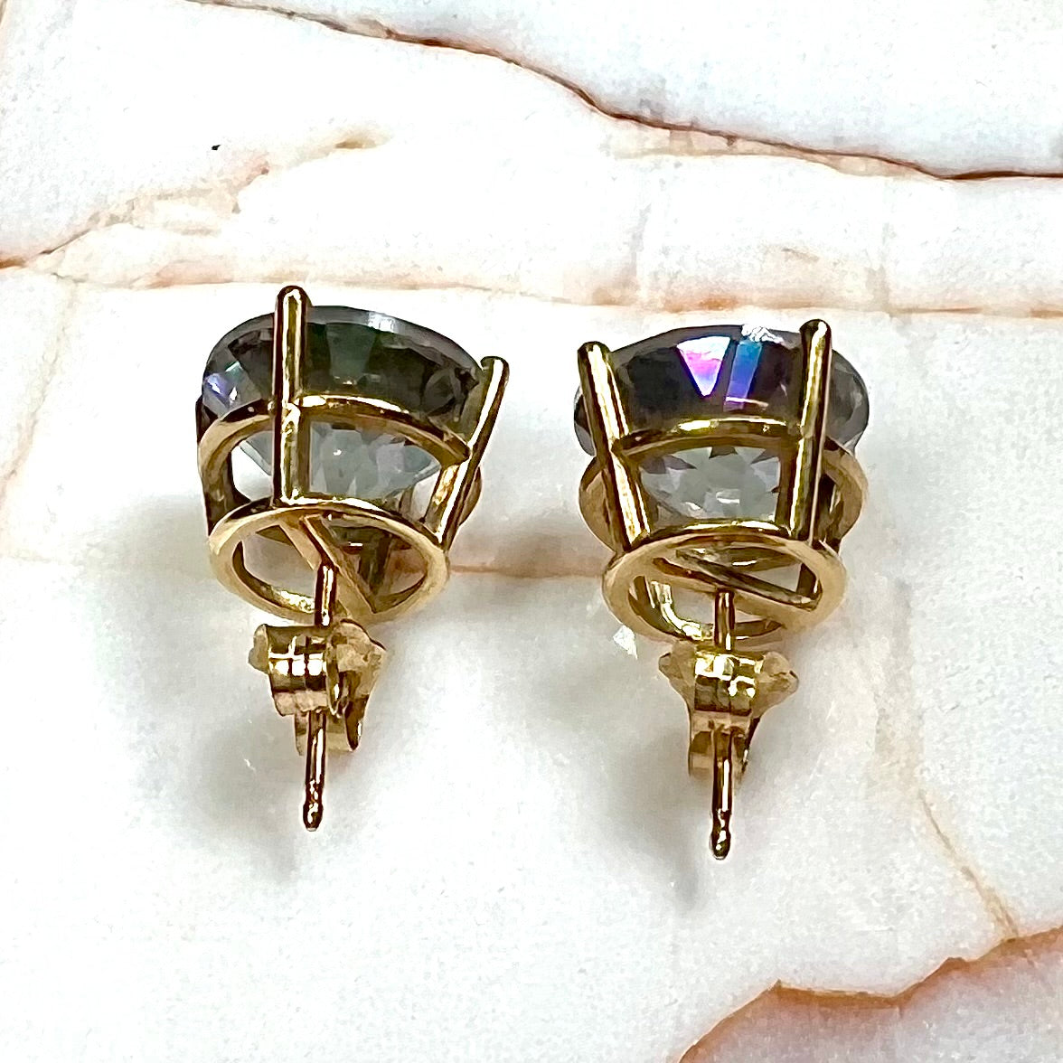 Round cut mystic topaz stones set in yellow gold prong-set push-back earrings.