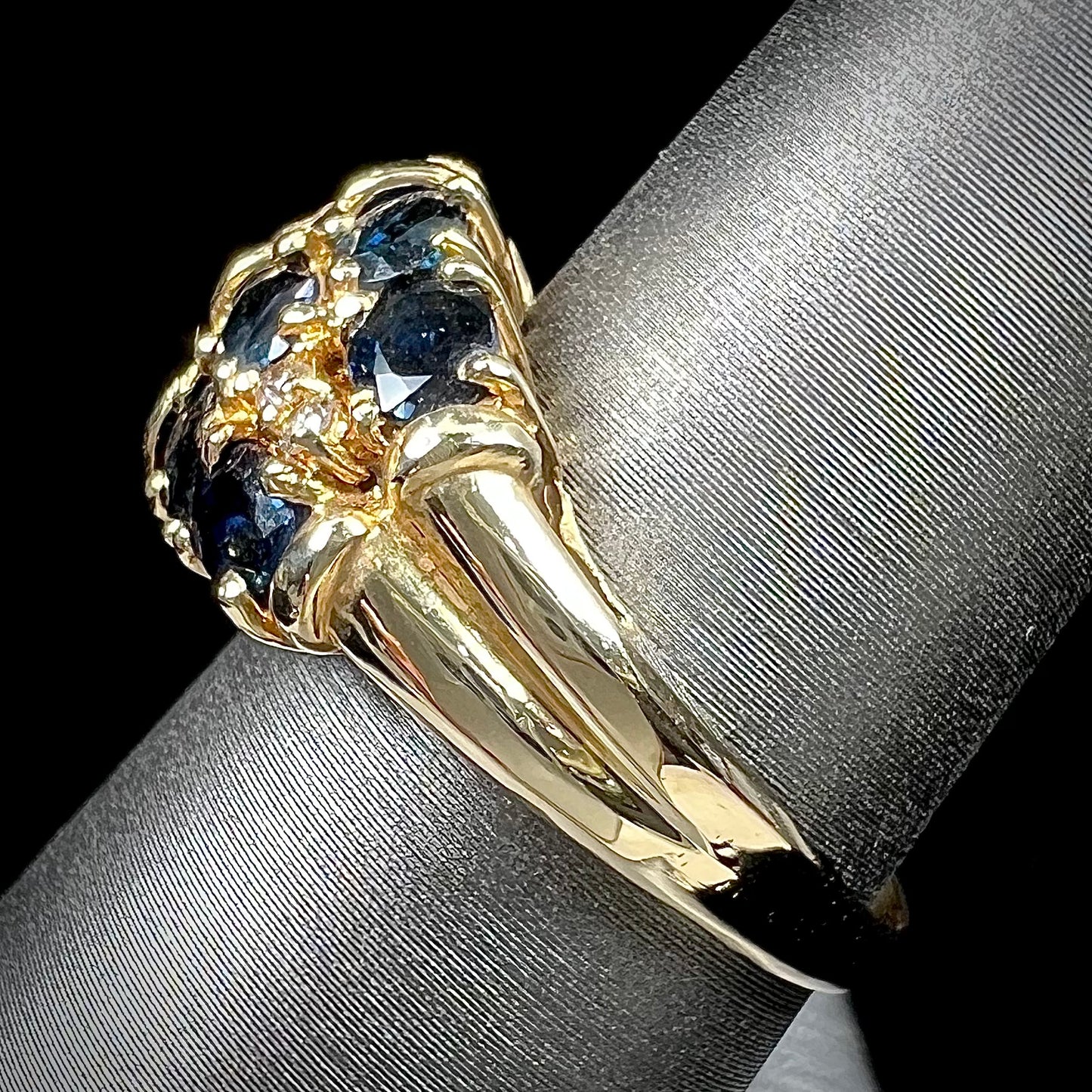 A vintage ladies' blue sapphire and diamond cluster ring cast in yellow gold.