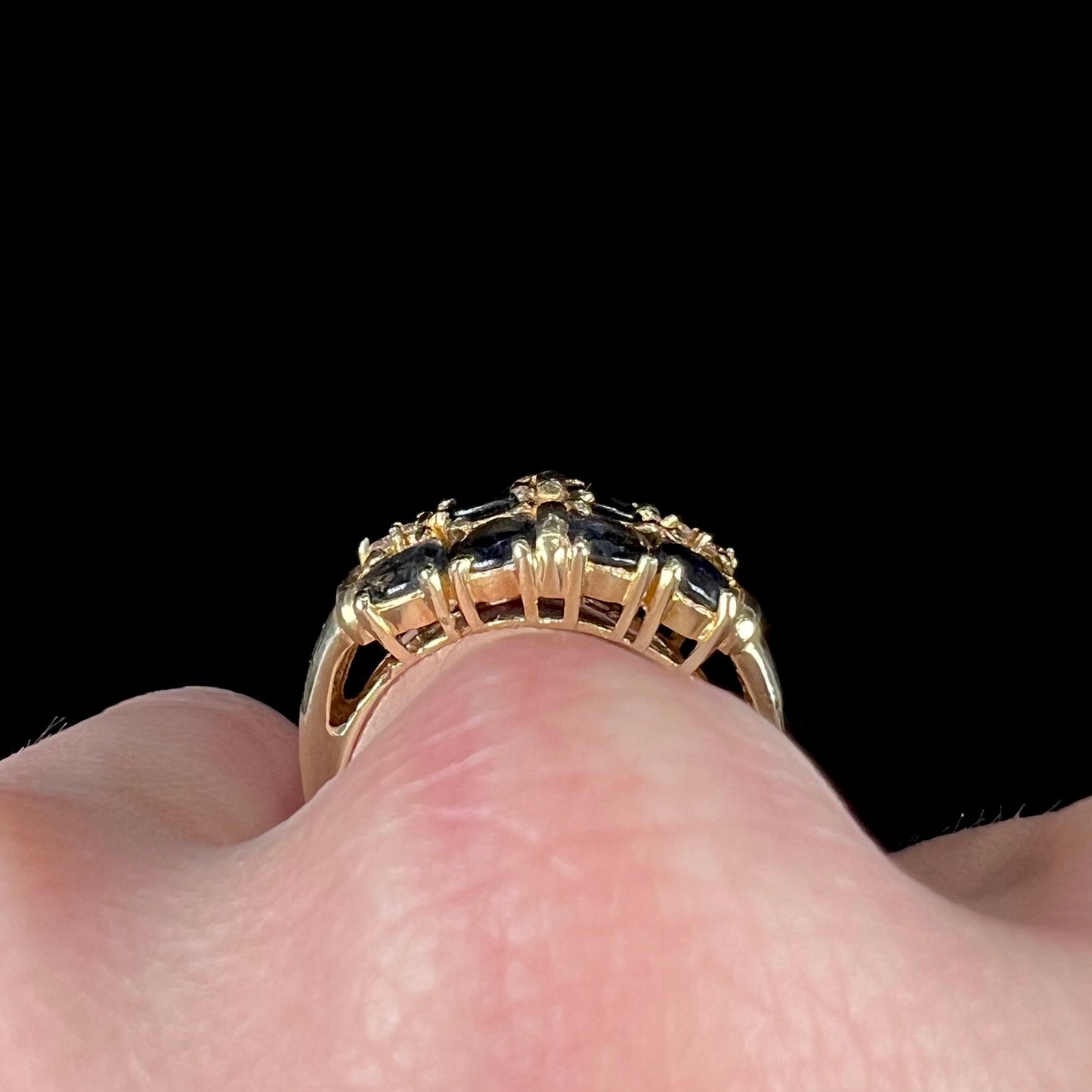 A vintage ladies' blue sapphire and diamond cluster ring cast in yellow gold.