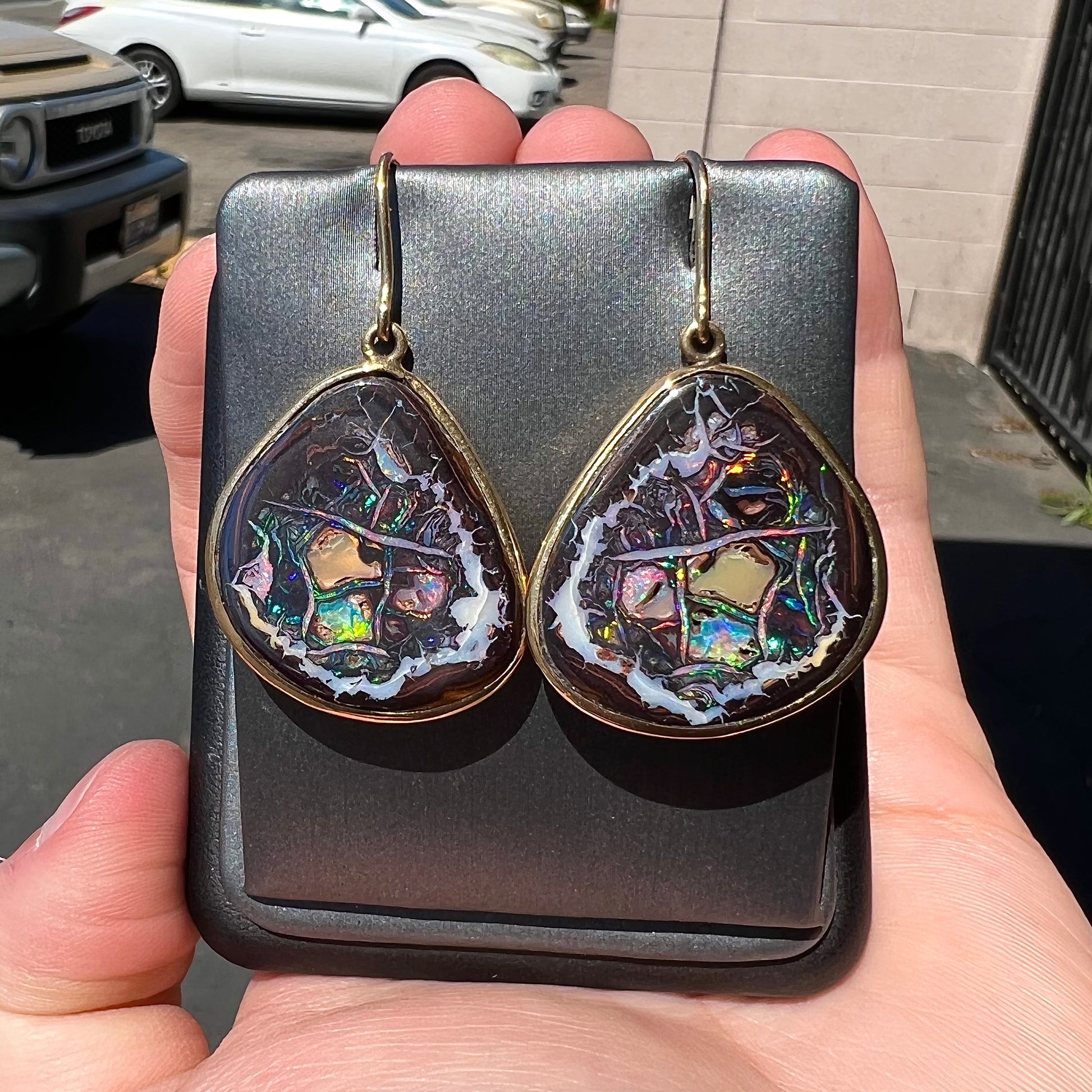 A pair of yellow gold bezel set Yowah nut boulder opal dangle earrings.