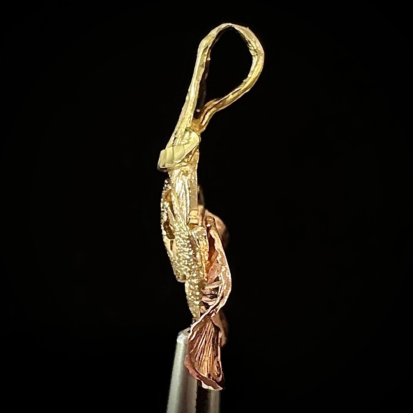 A small gold clown pendant charm. The clown's face and hat are yellow gold, and his neck frills are rose gold.
