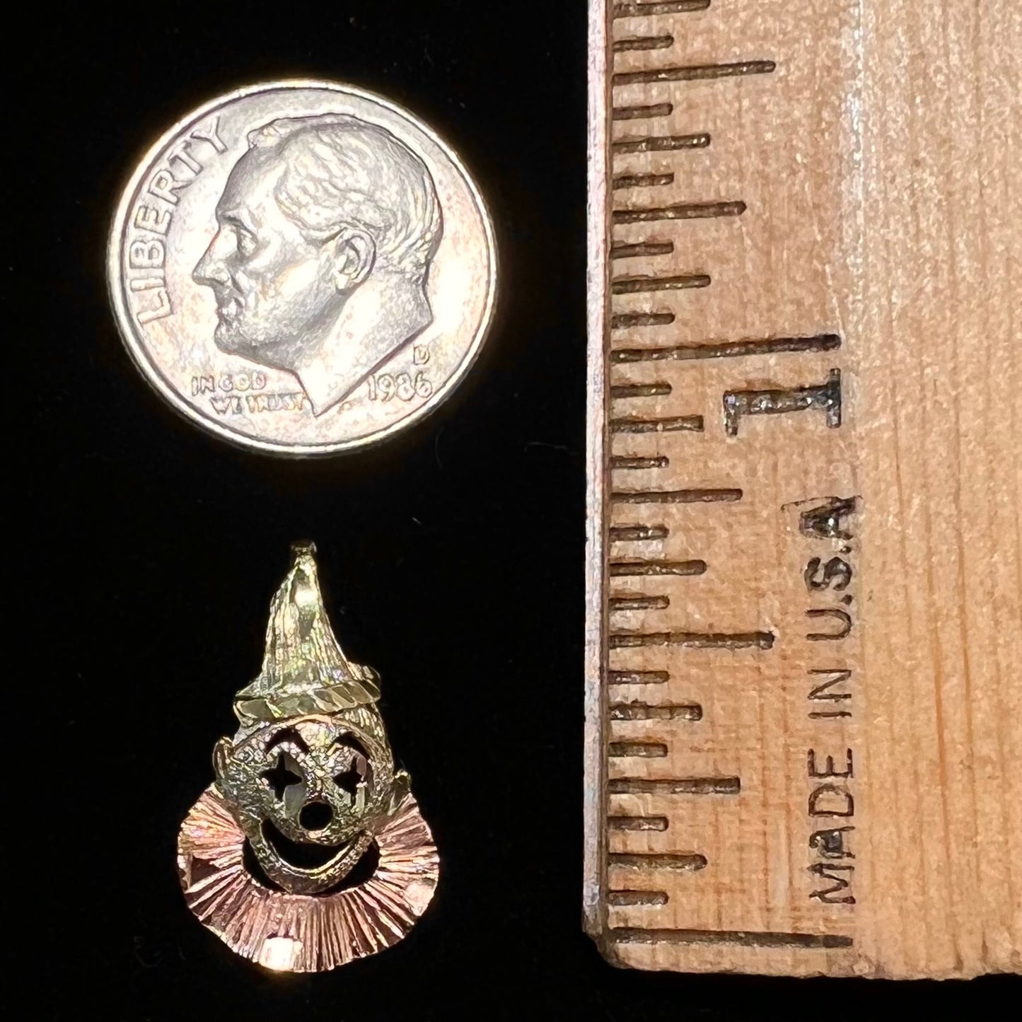 A small gold clown pendant charm. The clown's face and hat are yellow gold, and his neck frills are rose gold.
