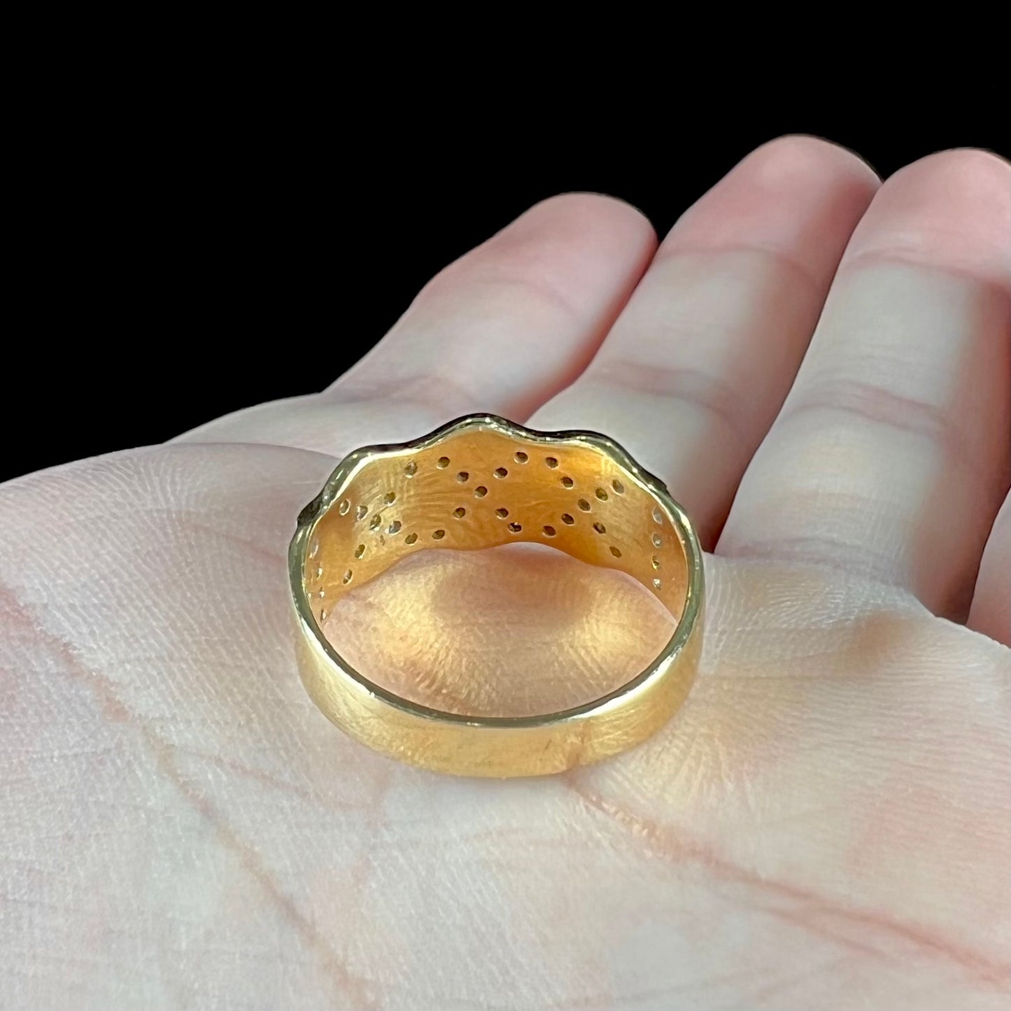 An 18kt yellow gold ring with three "X" shapes pave set with round diamonds.