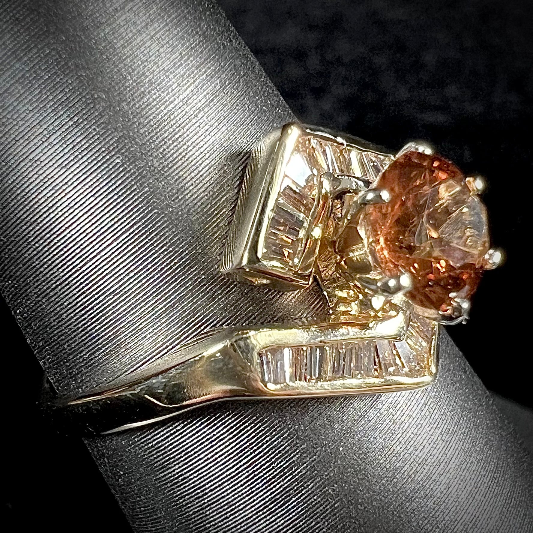A yellow gold ladies' golden topaz ring set with baguette cut side diamonds.