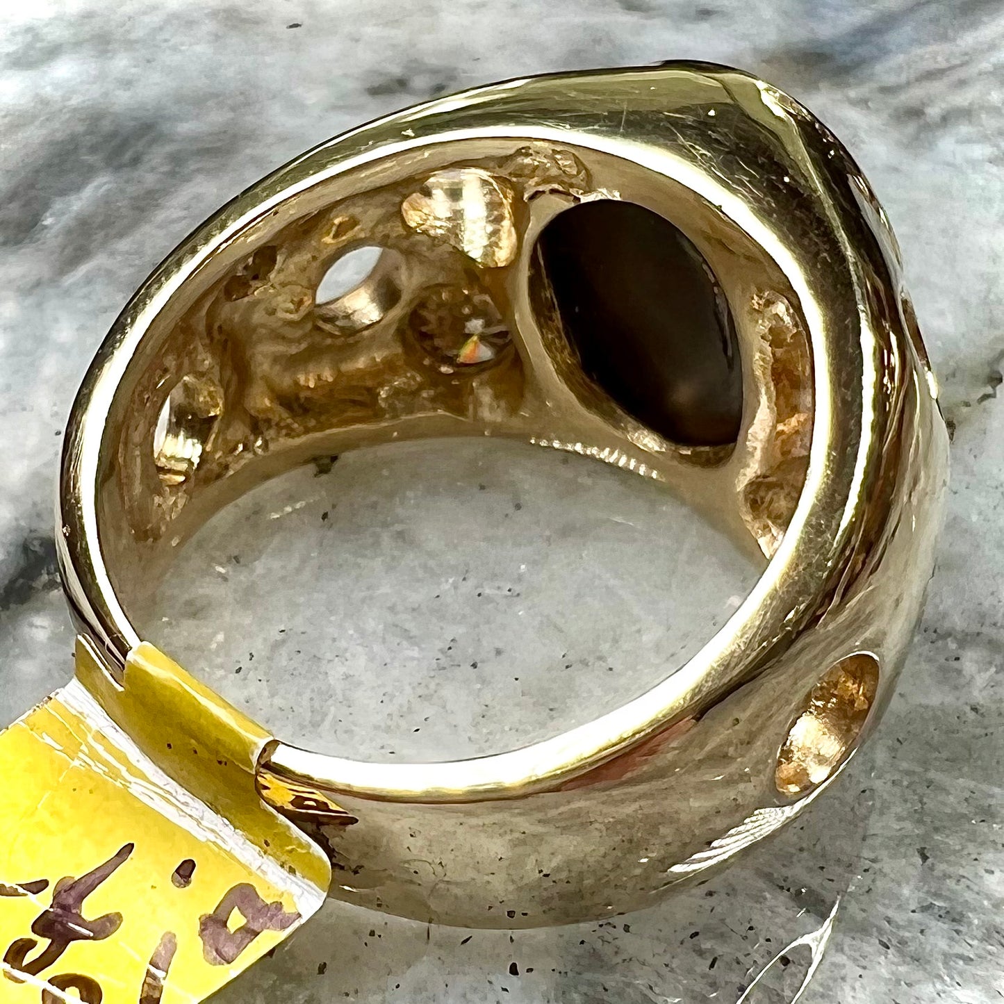 Men's rainbow fire agate ring set in yellow gold with champagne diamonds. The ring style has holes.