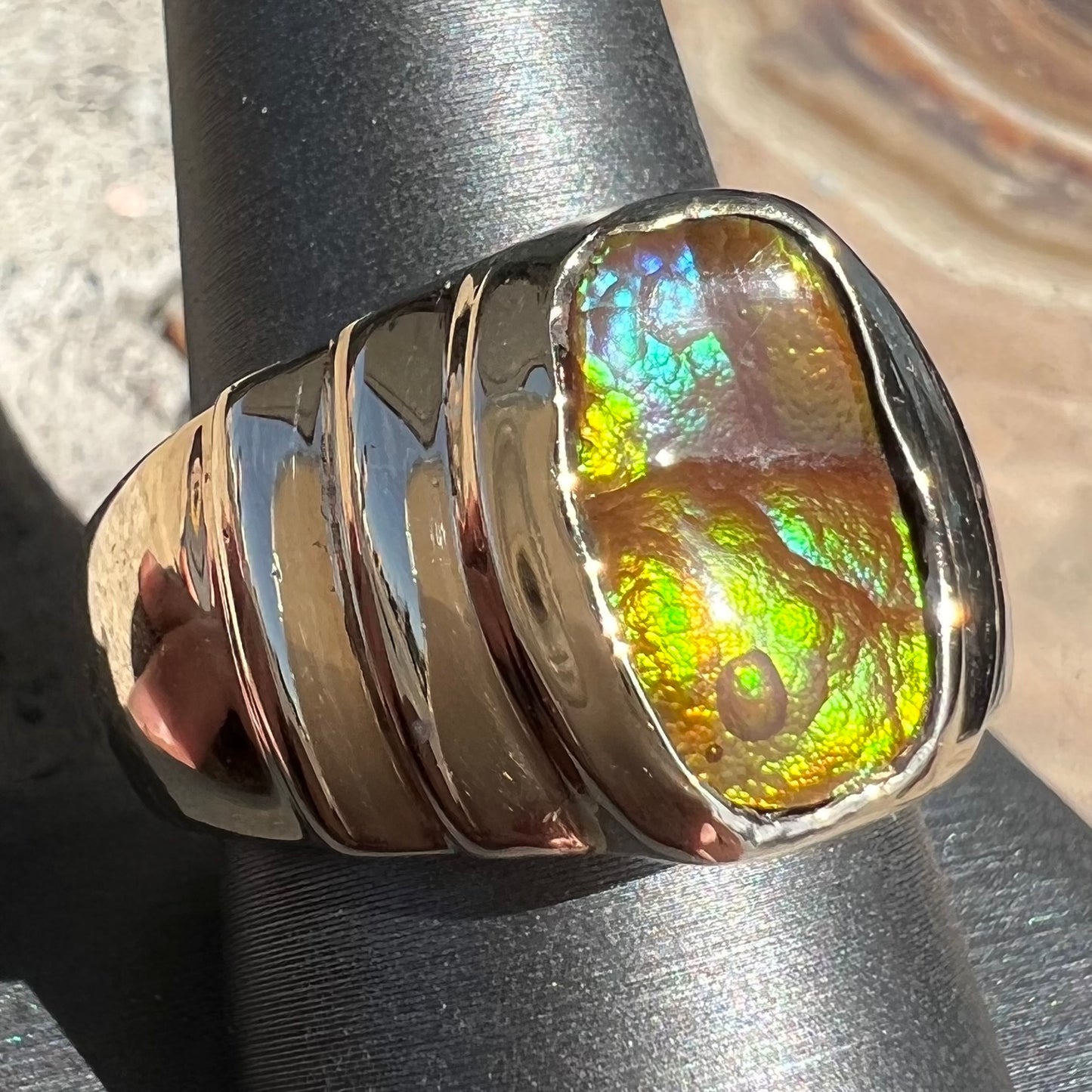 Men's fire agate solitaire ring cast in yellow gold. The ring is a step design.