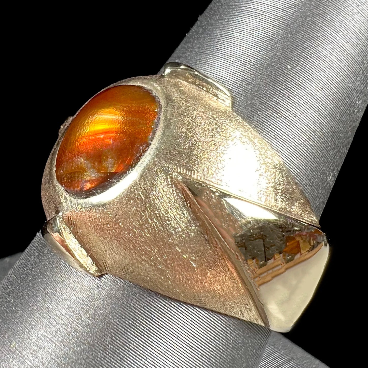 A men's brushed yellow gold fire agate ring with polished accents.