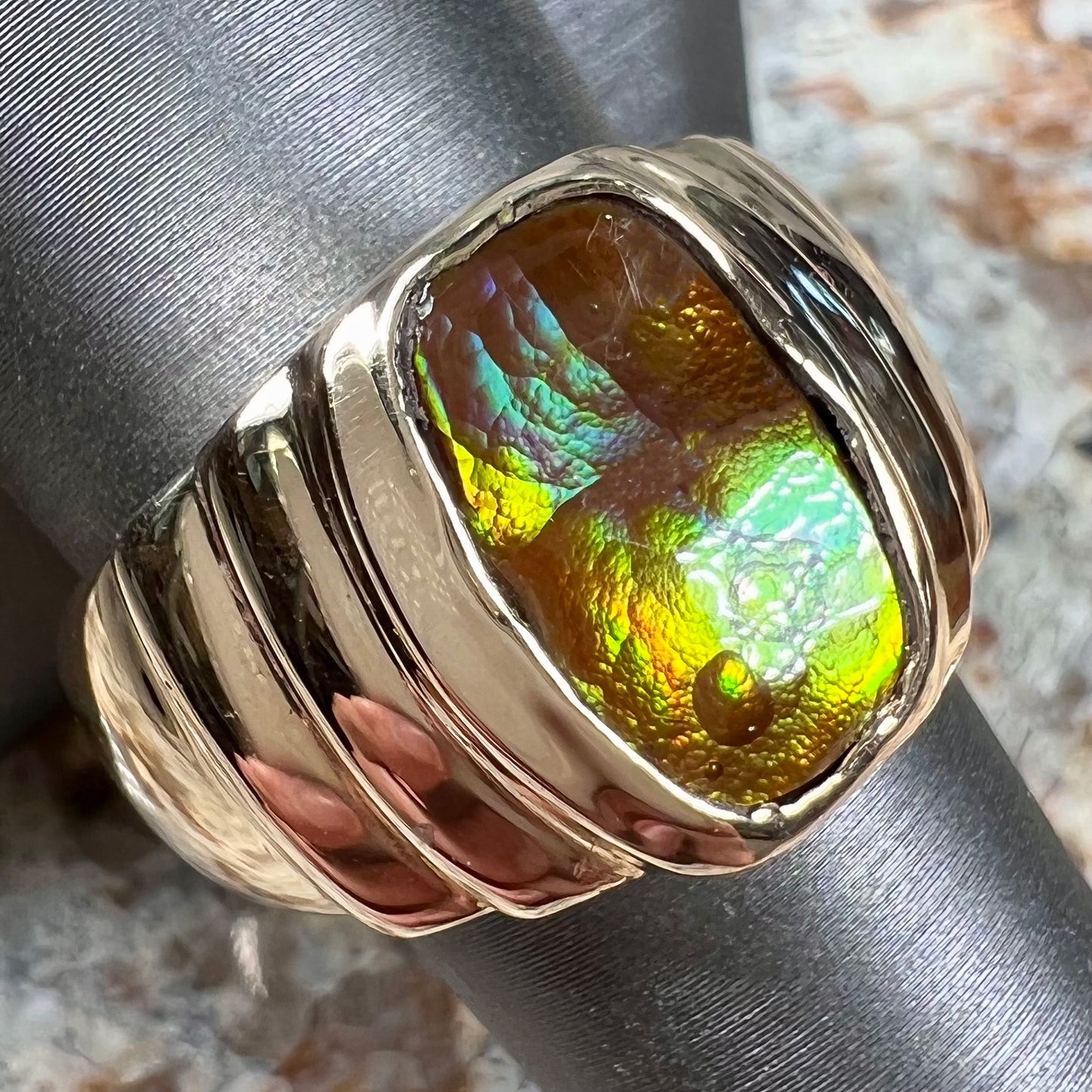 Men's fire agate solitaire ring cast in yellow gold. The ring is a step design.