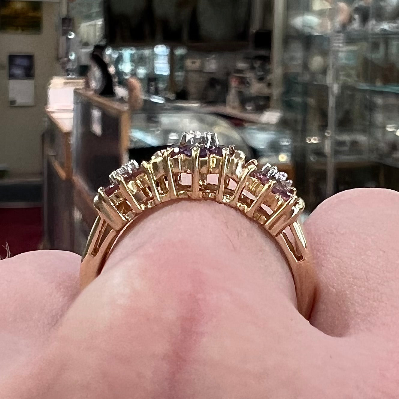 A vintage ladies' flower ring set with set with amethyst and pink tourmaline petals with a diamond center stone.