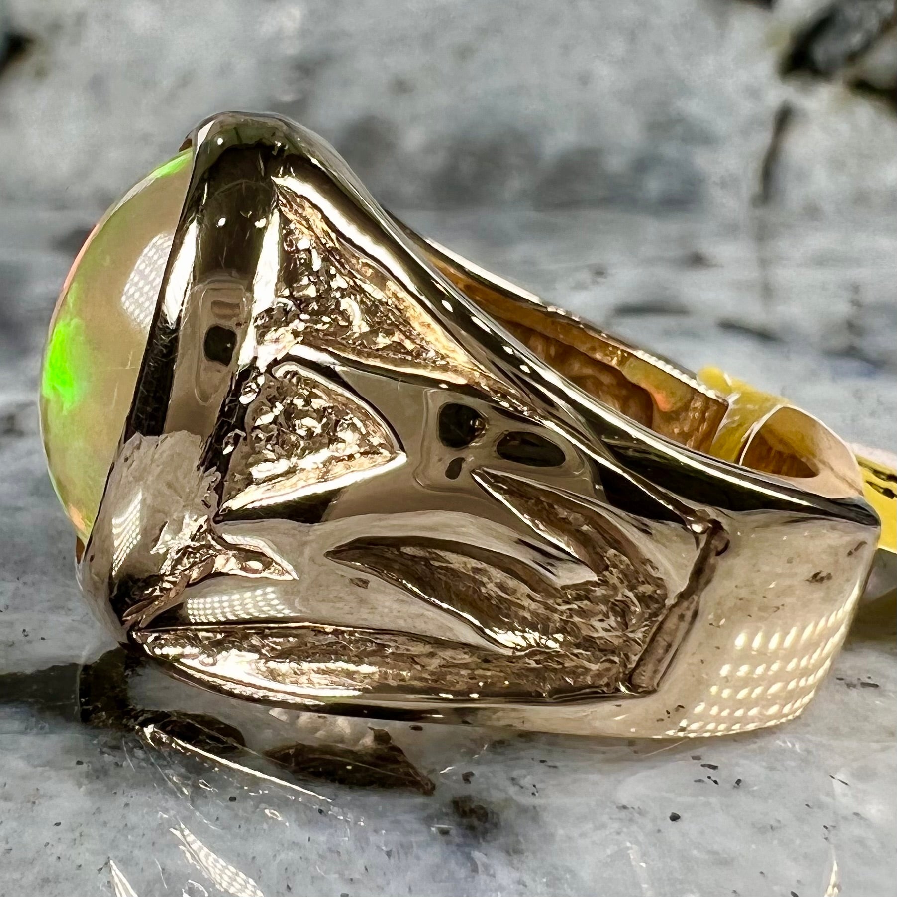 A solid yellow gold solitaire men's fire opal ring.  The stone is an orange oval cabochon cut.