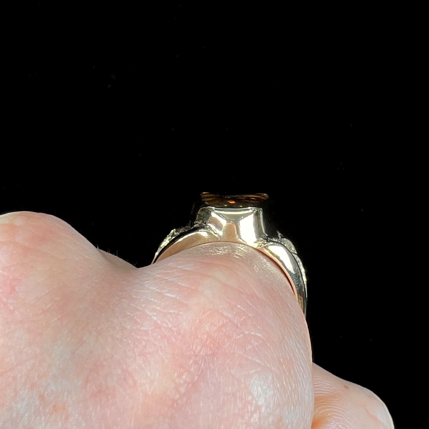 A men's yellow gold fire agate solitaire ring. The stone has a botryoidal pattern with sagenite inclusions.