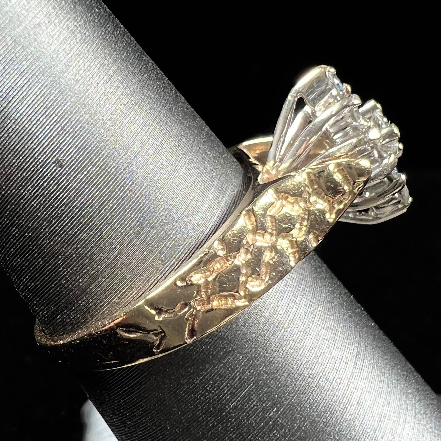 A ladies' estate diamond cluster ring cast in yellow gold. The shank has a nugget design.