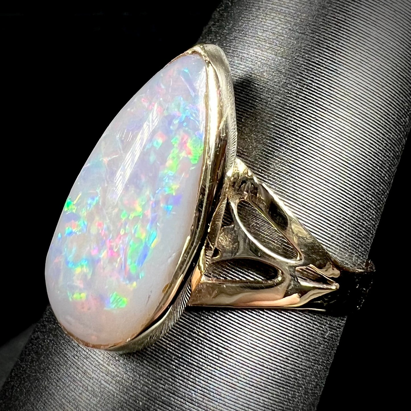 A ladies' pear shaped white crystal opal solitaire ring handmade in yellow gold.