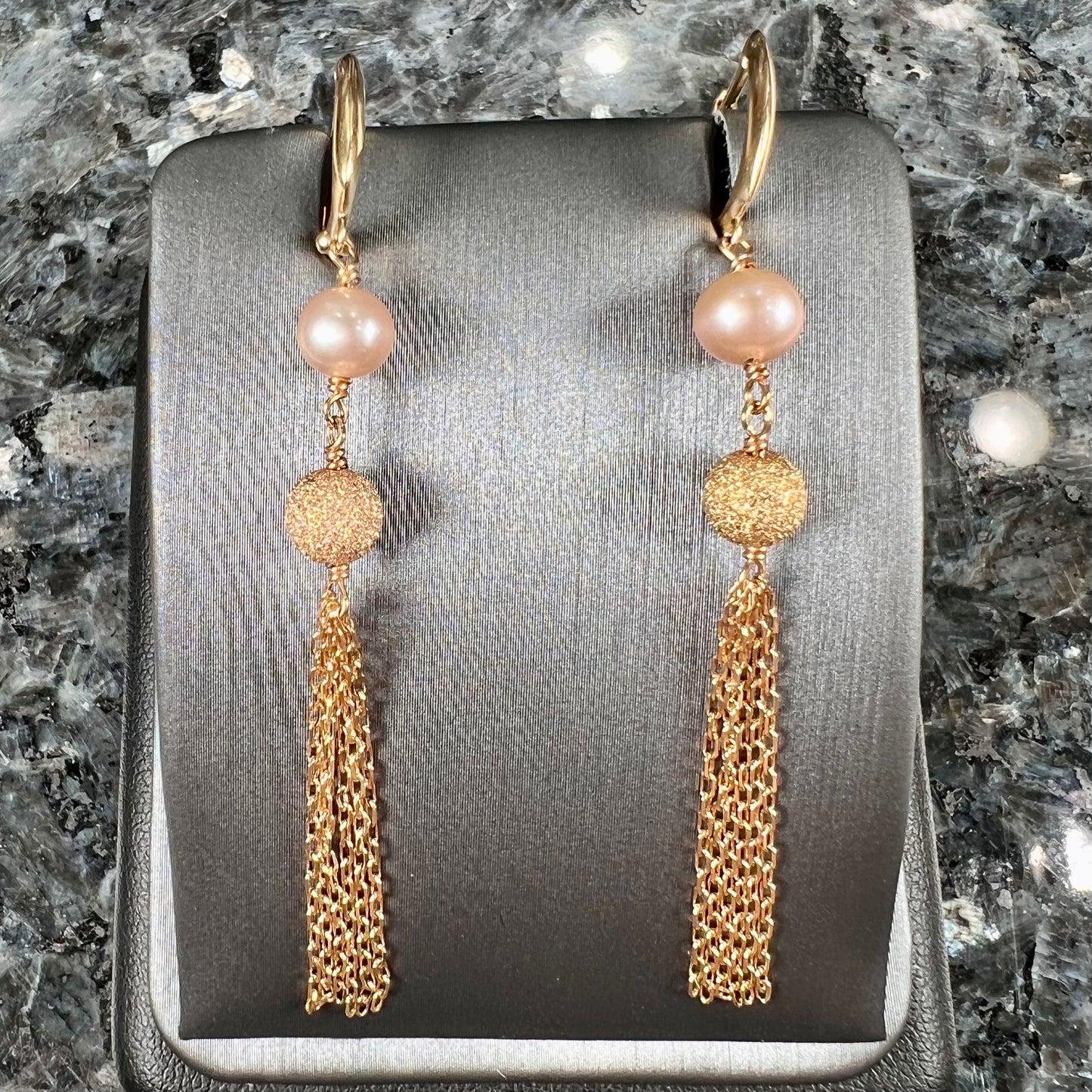 A pair of yellow gold and pink pearl dangle earrings.