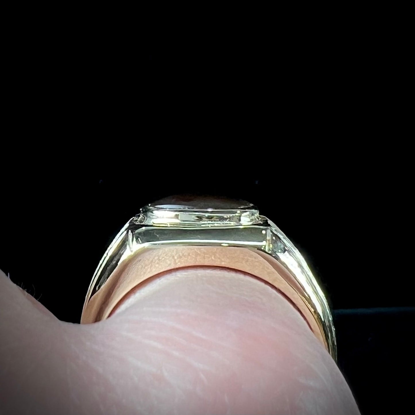 A yellow gold men's fire agate solitaire ring. The fire agate is red with green undertones.