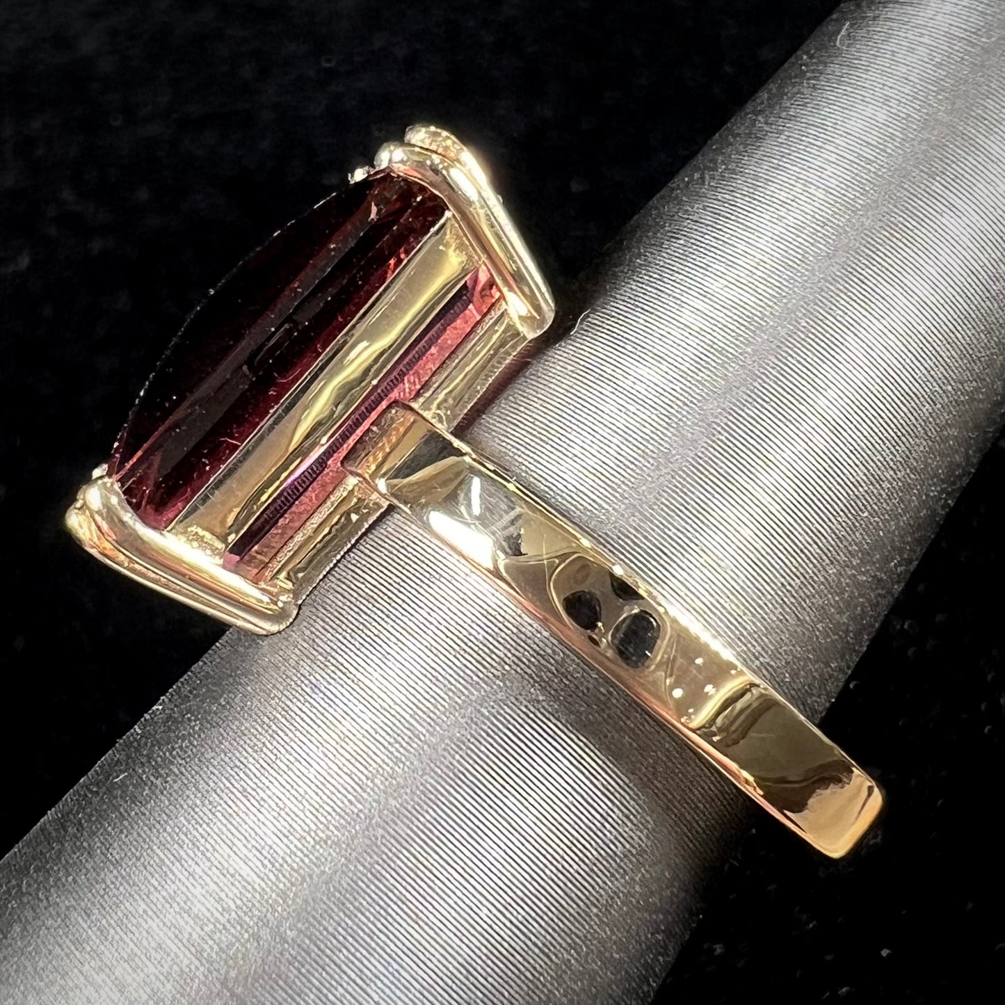 A handmade yellow gold solitaire ring set with a 7.91ct pinkish purple pixel cut tourmaline stone.
