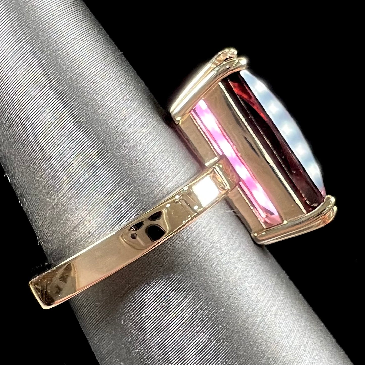 A handmade yellow gold solitaire ring set with a 7.91ct pinkish purple pixel cut tourmaline stone.