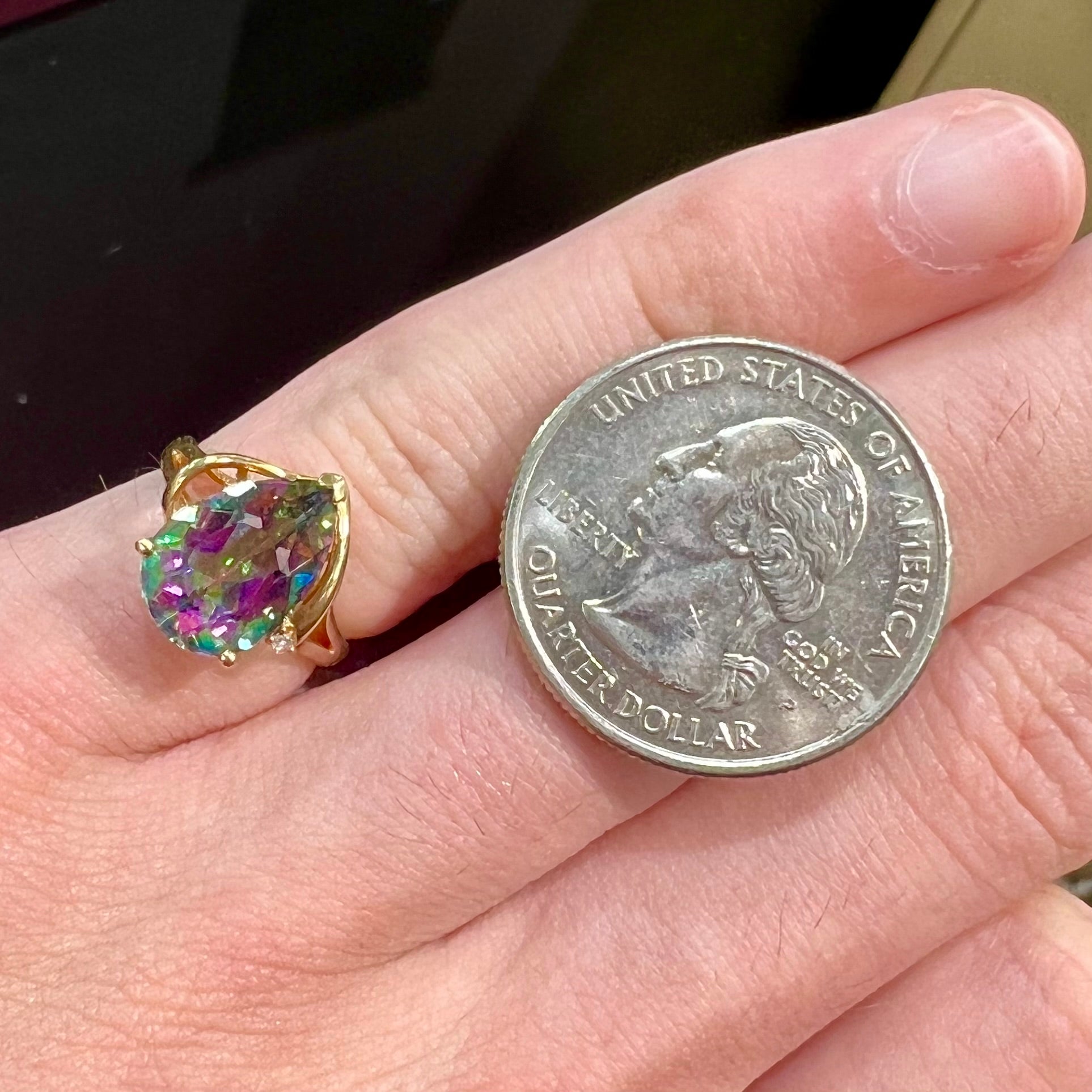 Pear shape green and pink mystic topaz set in a yellow gold ring with a single round diamond.