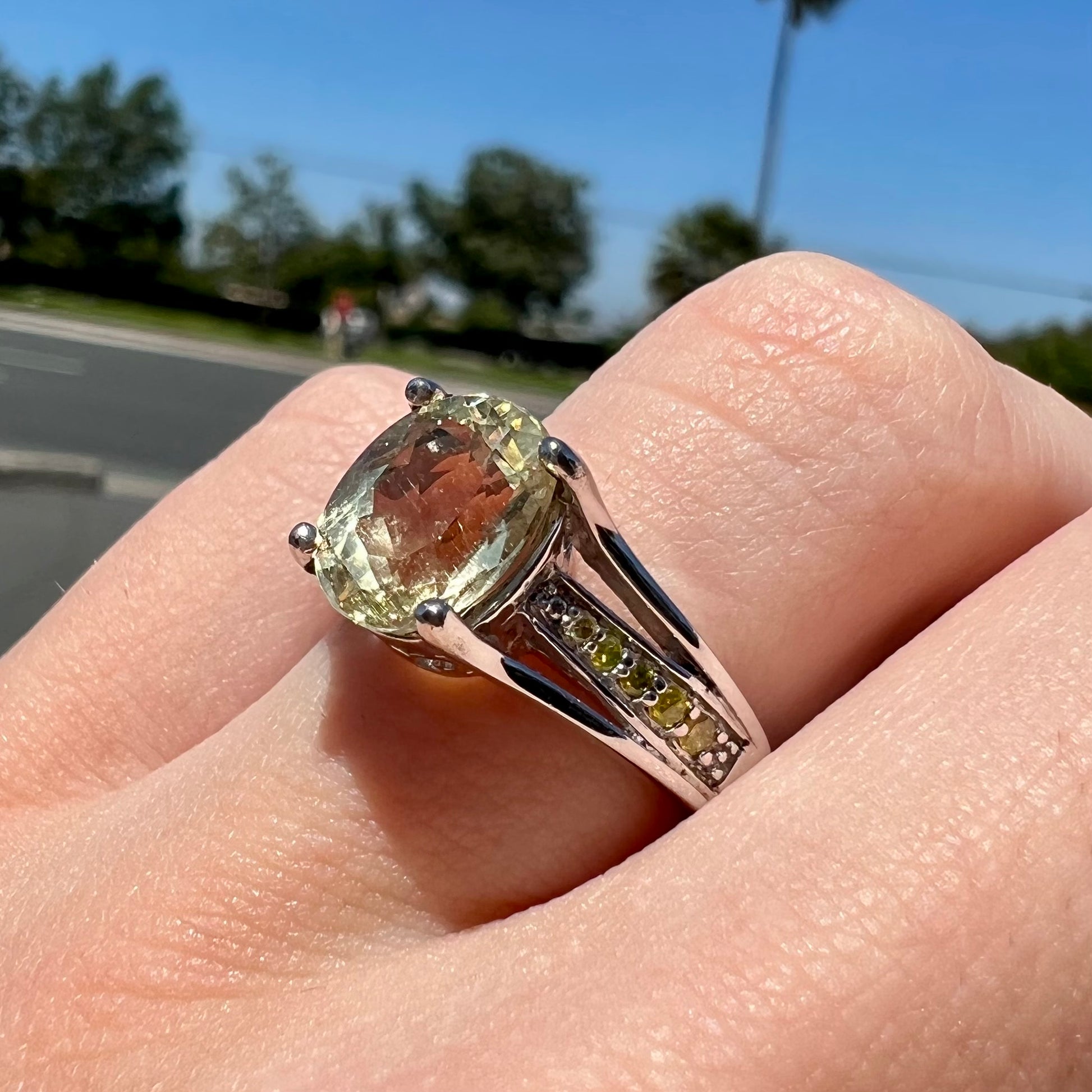 A sterling silver oval cut citrine ring set with canary yellow diamond accents.
