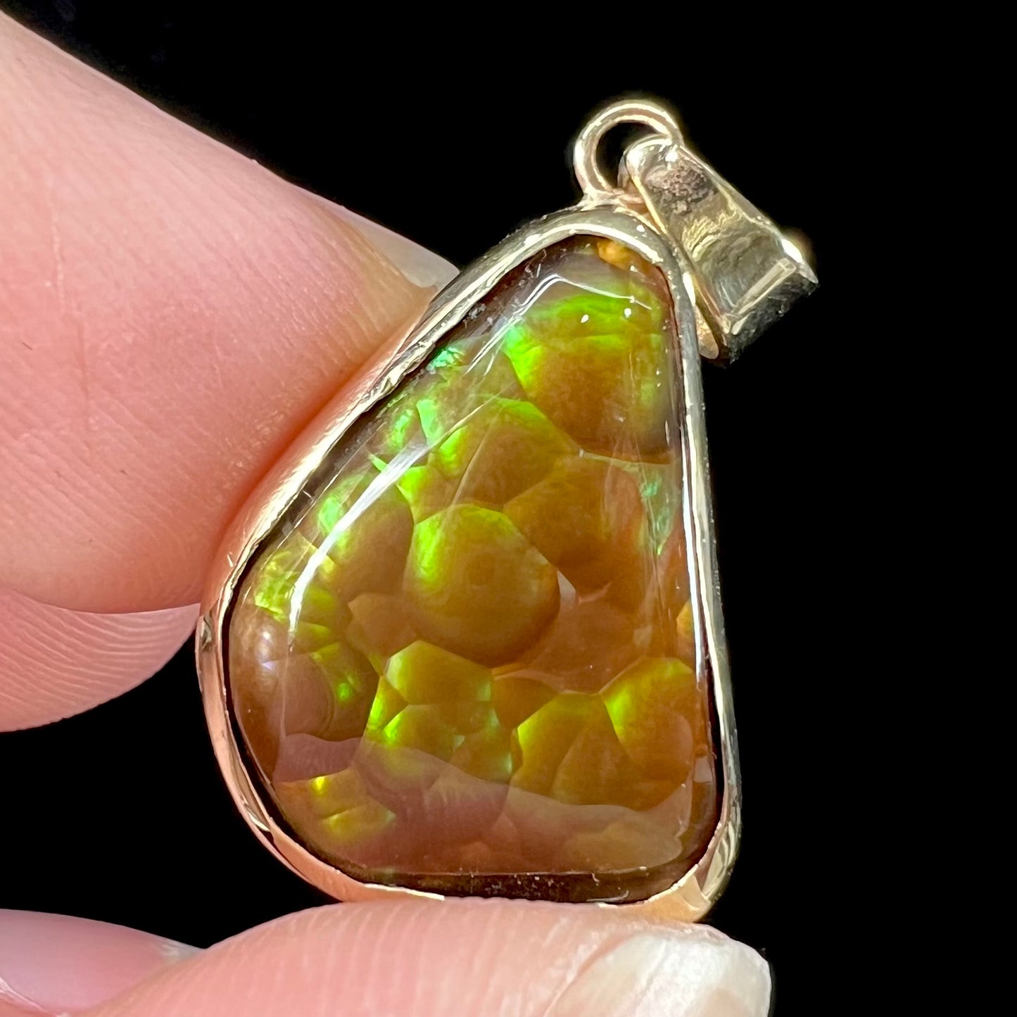 A handmade yellow gold solitaire pendant set with a green fire agate stone from Mexico.
