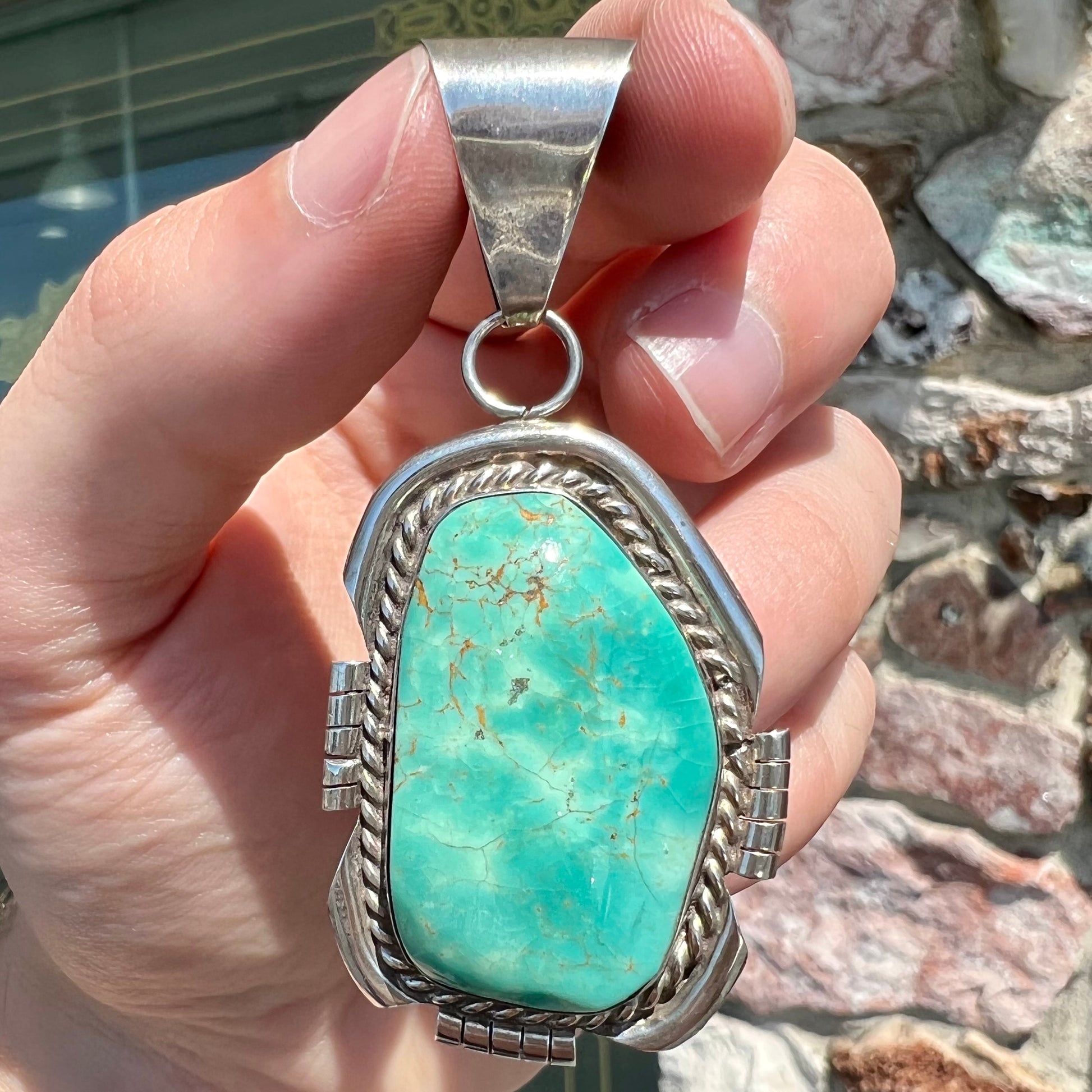 A men's silver Navajo pendant set with a turquoise stone from Pilot Mountain Mine, Nevada.