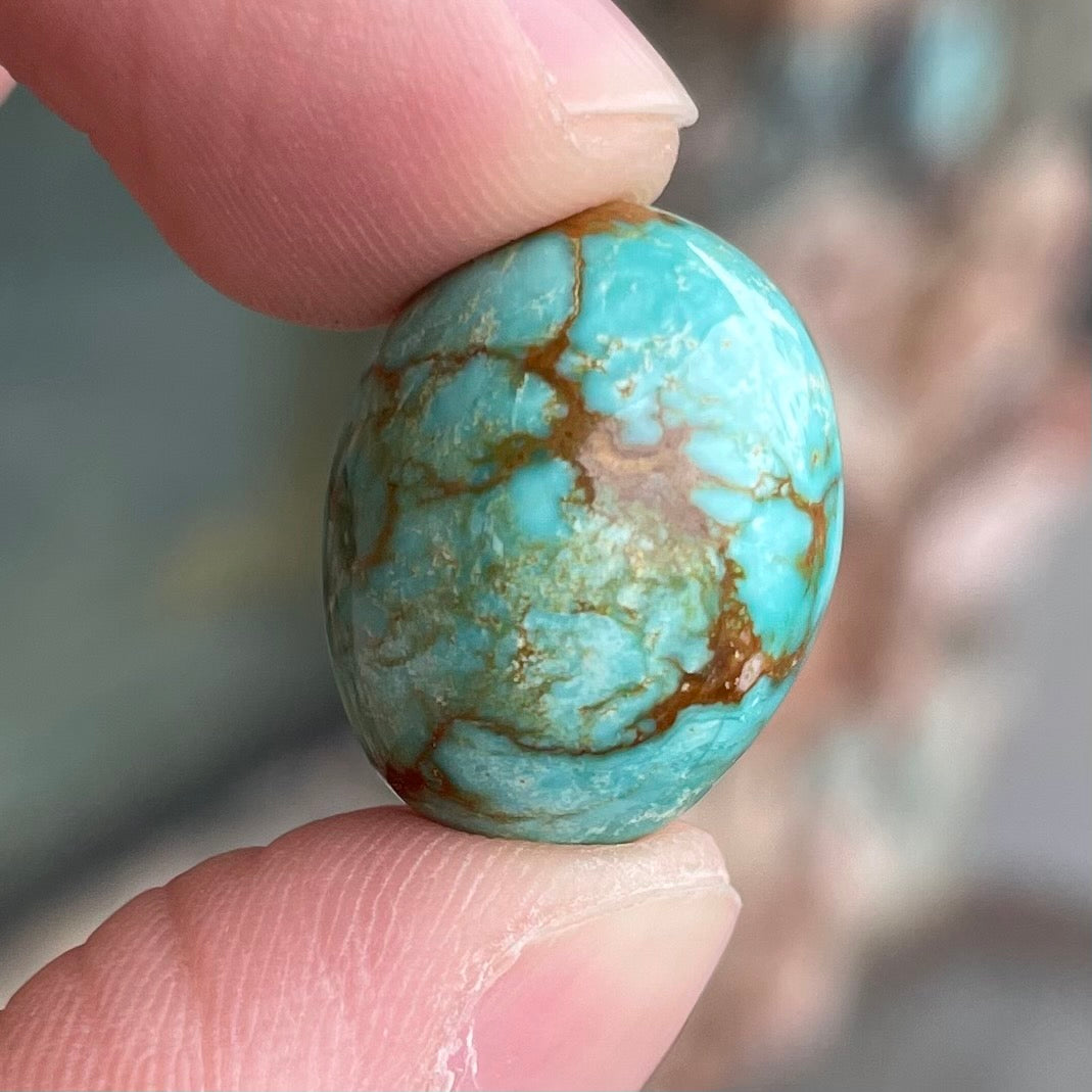 A loose, greenish blue turquoise stone with brown matrix from the Royston Mining District in Nevada.