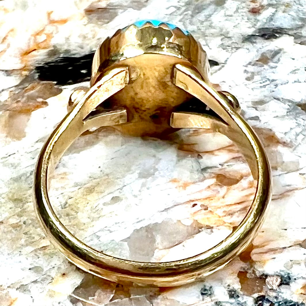 A ladies' yellow gold turquoise ring. The turquoise is a round cabochon cut.