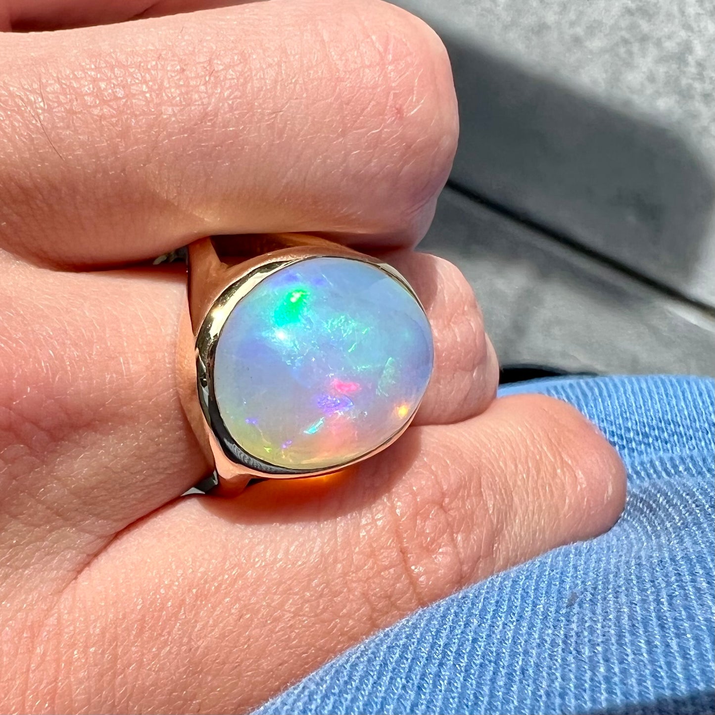 A gold split shank solitaire ring set with an oval cabochon cut 16.83 carat Ethiopian jelly fire opal.
