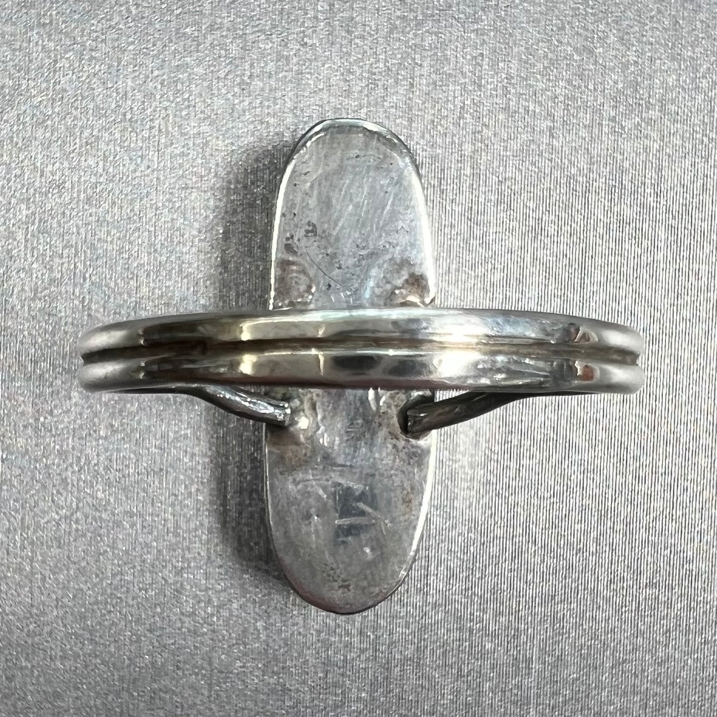 A handmade silver turquoise ring inlaid with six pieces of Sleeping Beauty turquoise. The back of the ring is signed "FT".