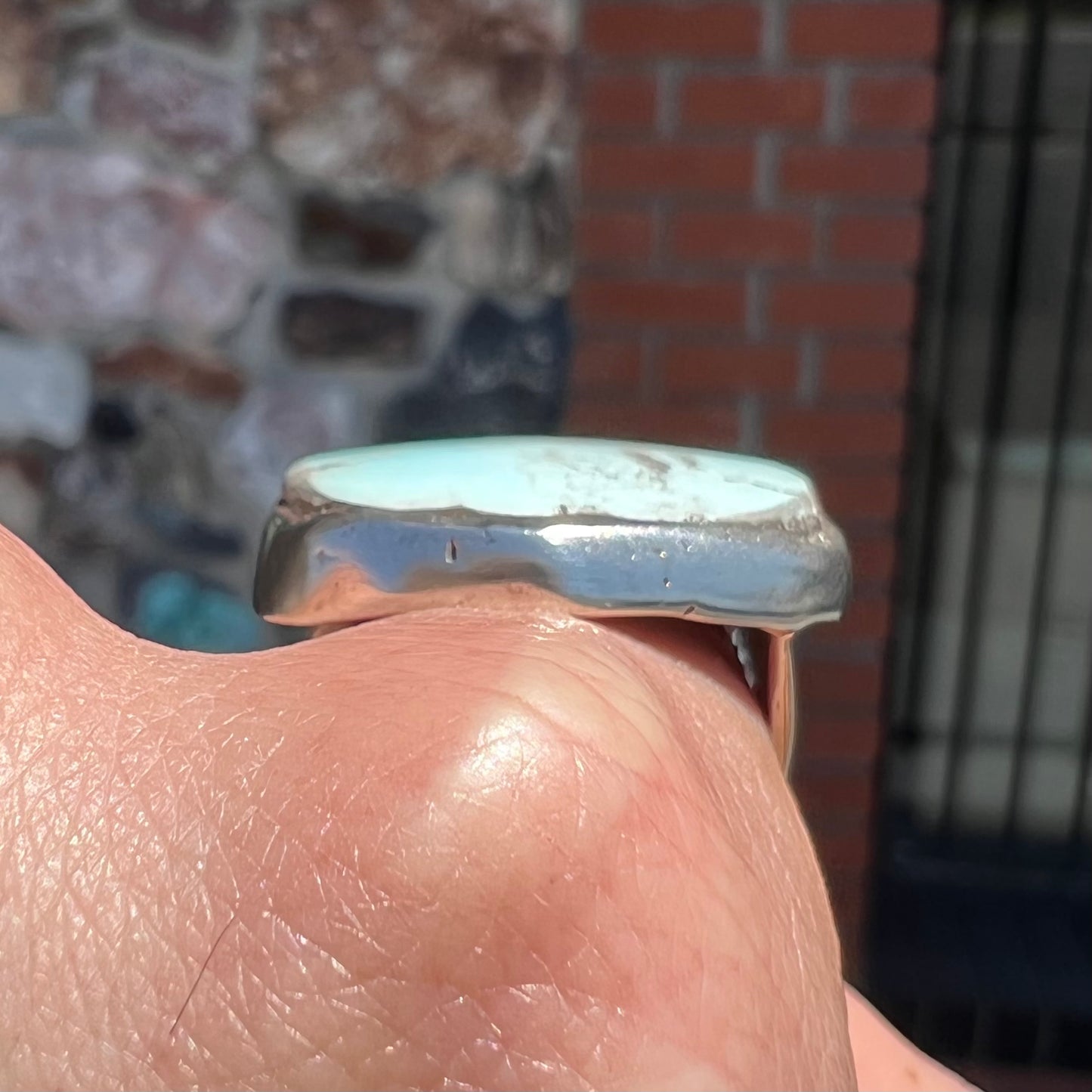 A men's sterling silver ring set with a powder blue turquoise stone. The ring is rustic style.