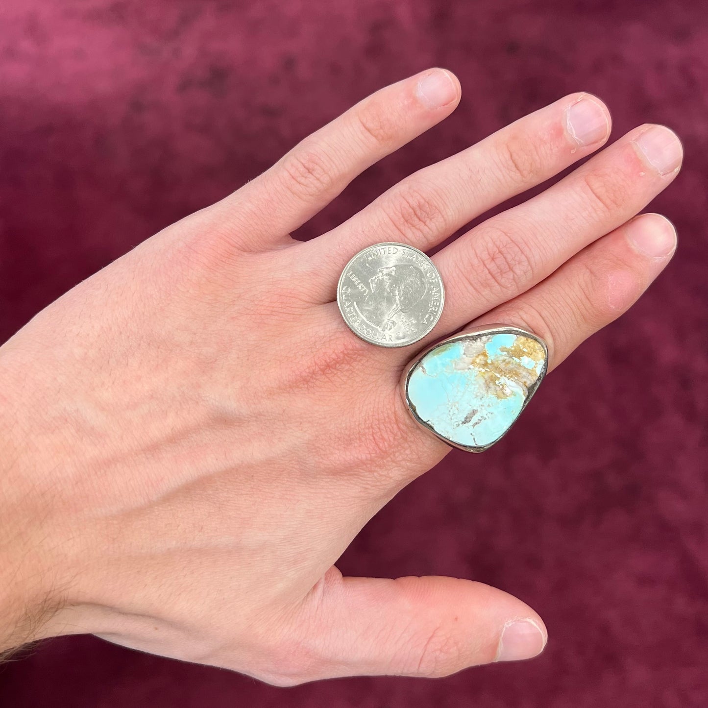 A men's sterling silver ring set with a powder blue turquoise stone. The ring is rustic style.