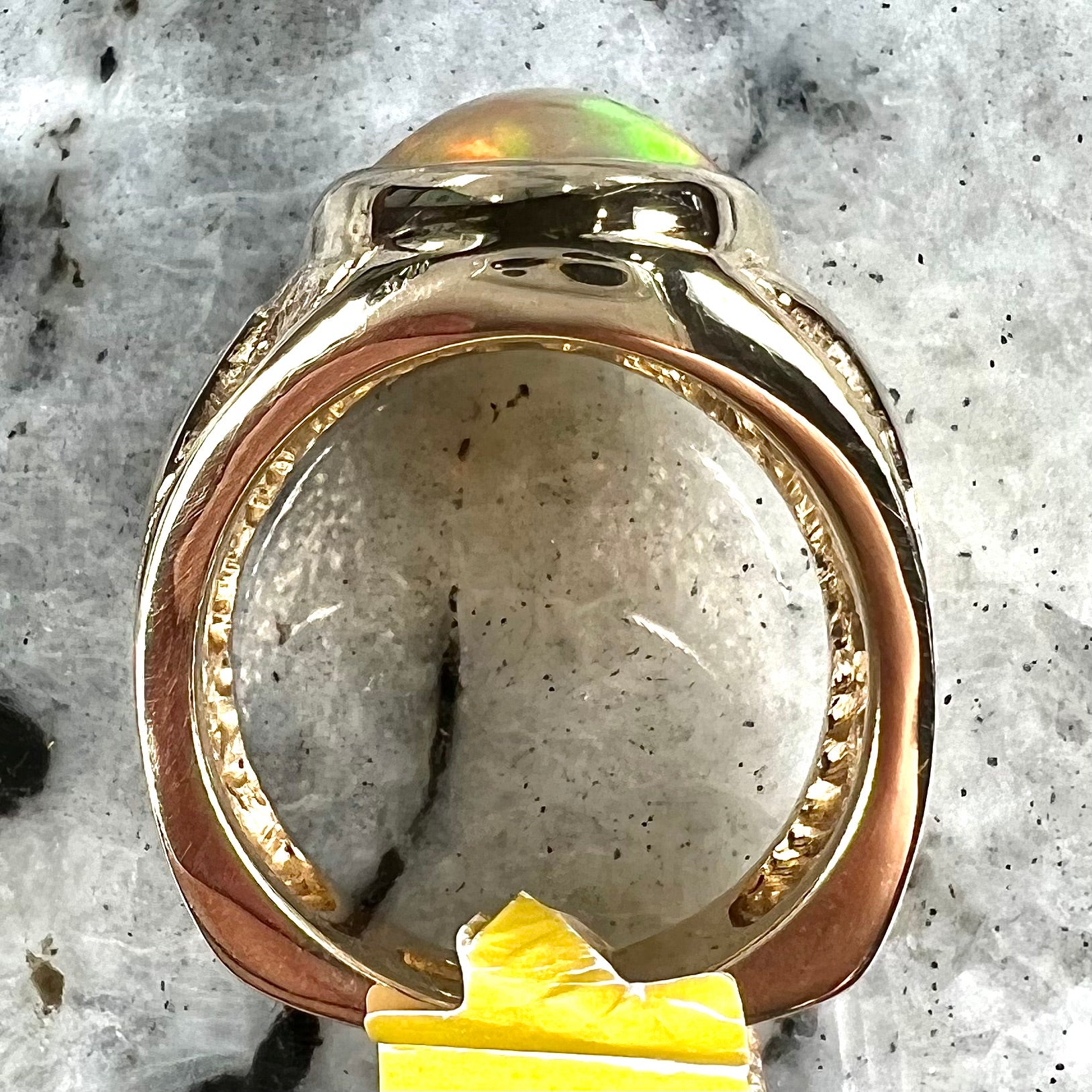 A solid yellow gold solitaire men's fire opal ring.  The stone is an orange oval cabochon cut.