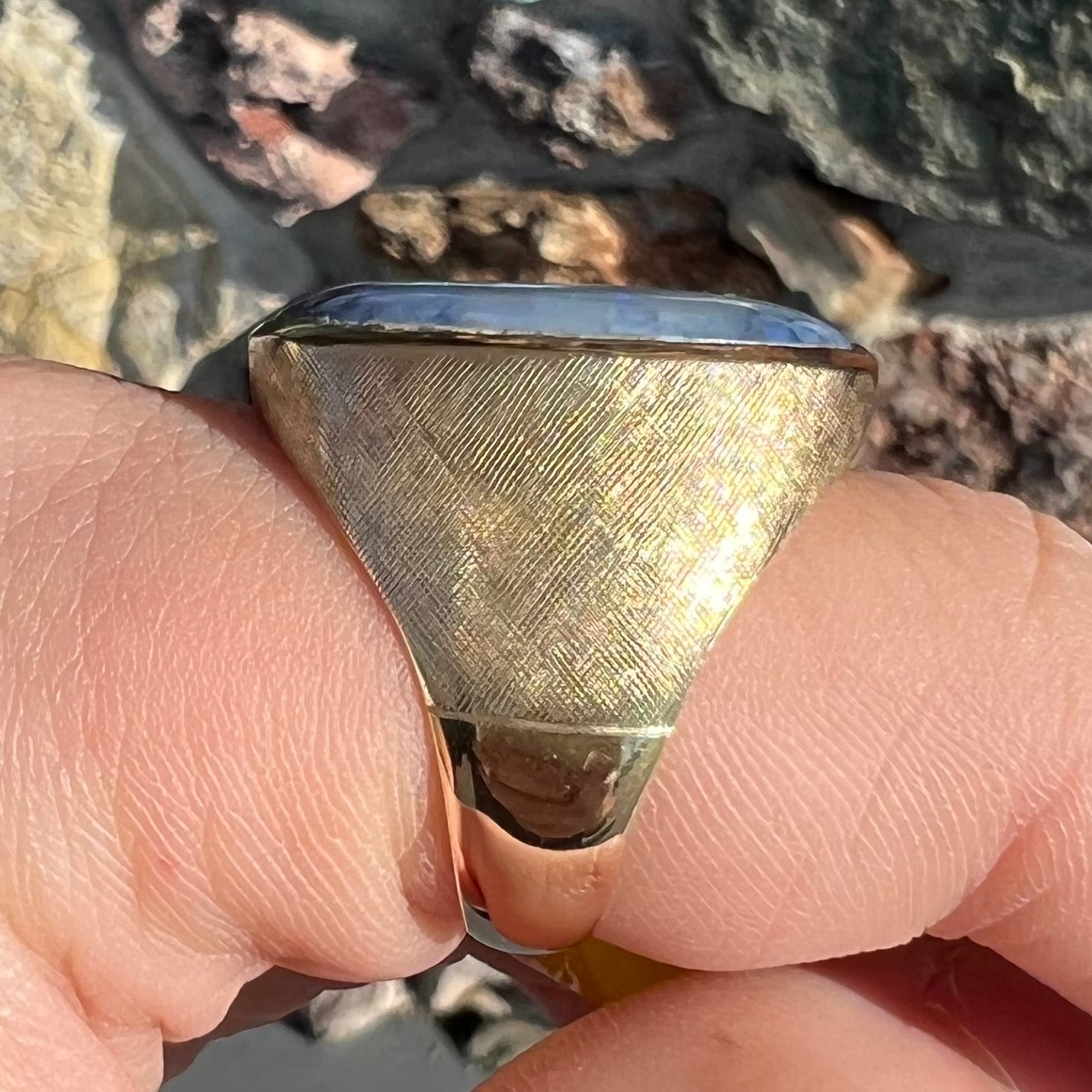 A Lightning Ridge black opal men's ring in solid yellow textured gold.