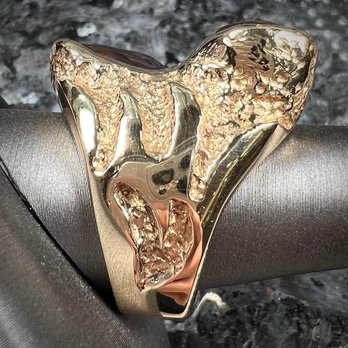 A men's Deer Creek fire agate solitaire ring cast in yellow gold. The stone is predominantly purple.