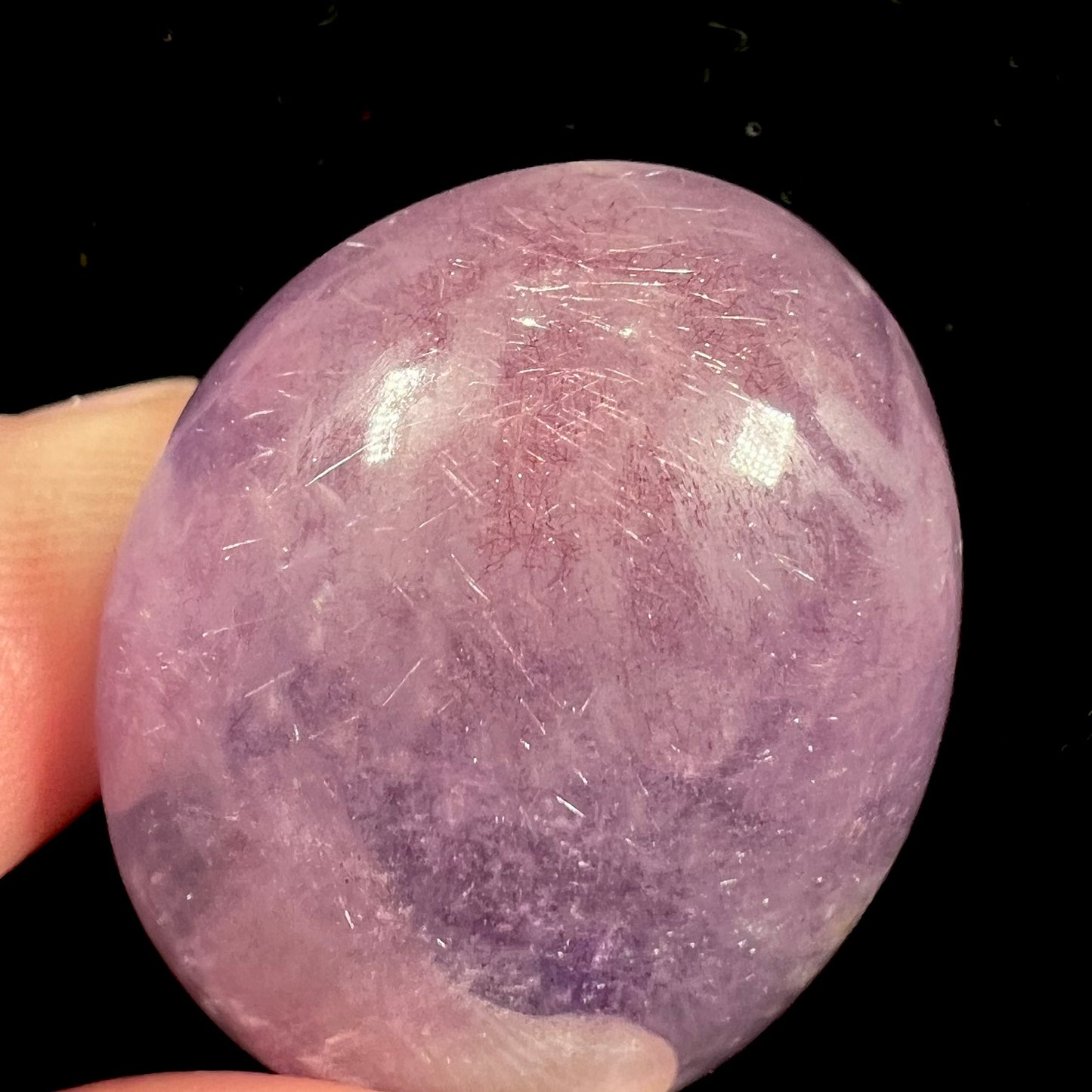 A cabochon cut red amethyst stone from Mexico. The piece shows a faint star.