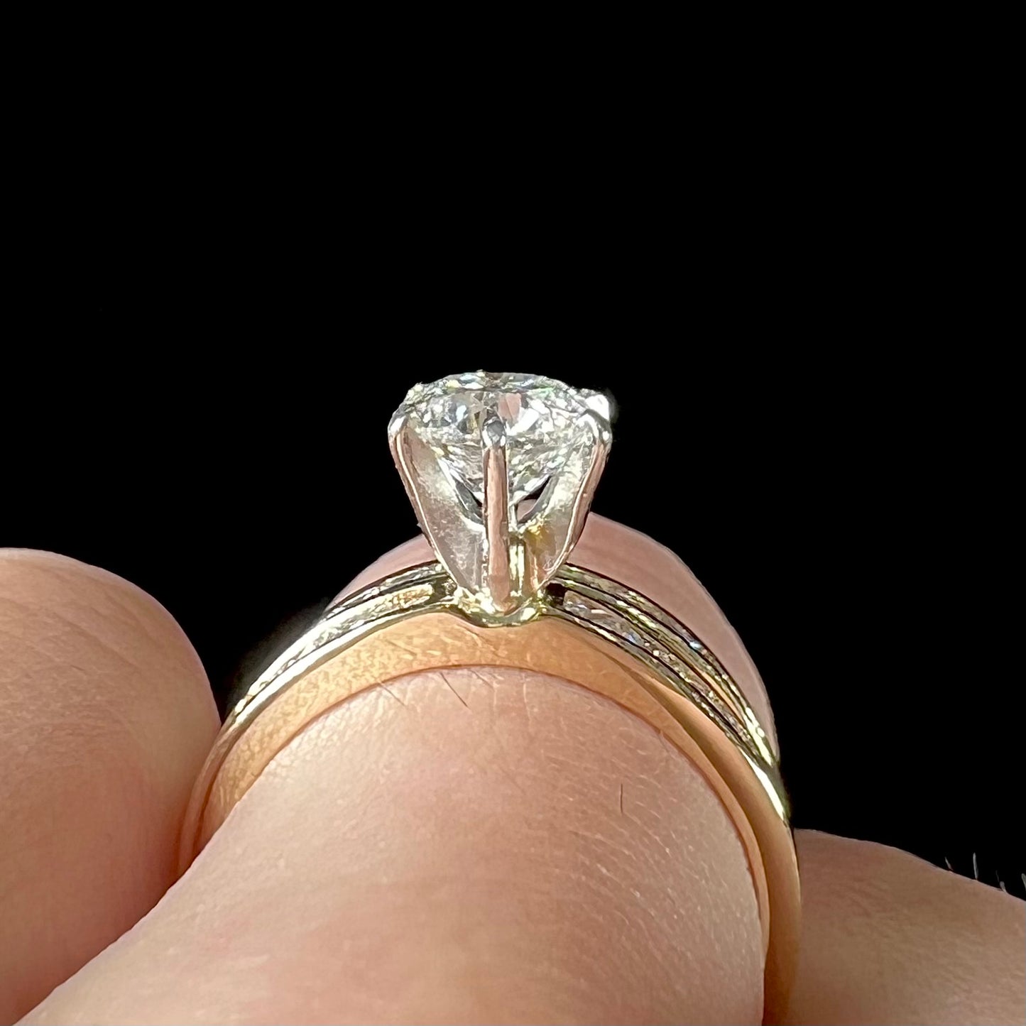 A diamond engagement and wedding ring set. The center stone is a 1 carat round diamond, and the side stones are channel set princess cut diamonds.