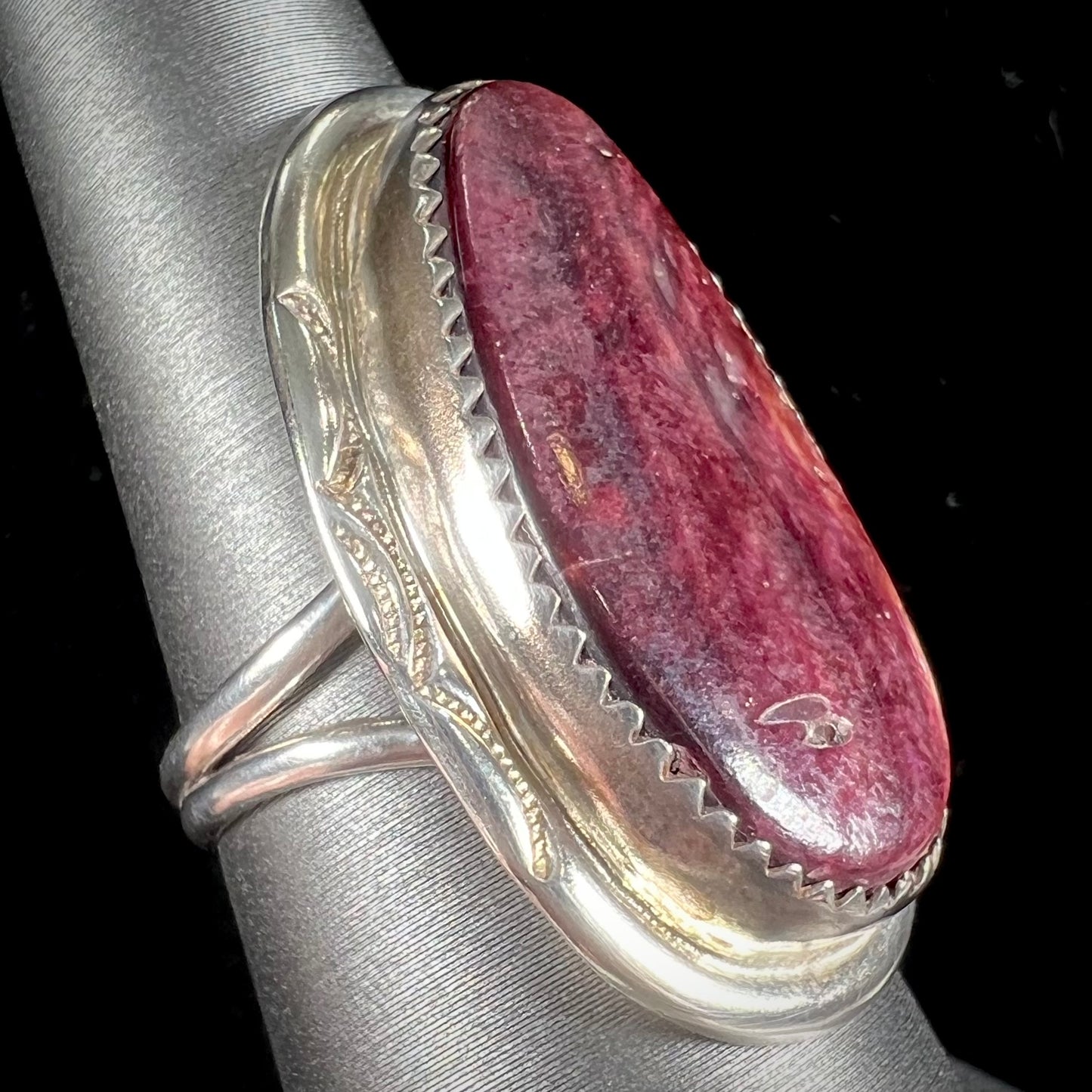 A sterling silver ring set with a purple spiny oyster shell, handmade by the Hopi Indian artist.