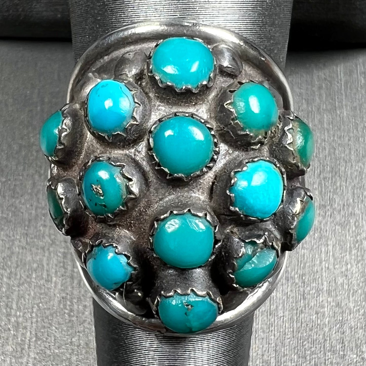 A handmade, unisex Hopi silver ring set with 14 round turquoise cabochons.