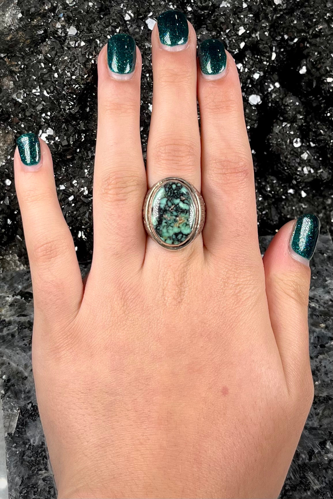 A sterling silver solitaire ring set with a black spiderweb turquoise stone from Kingman, Arizona.