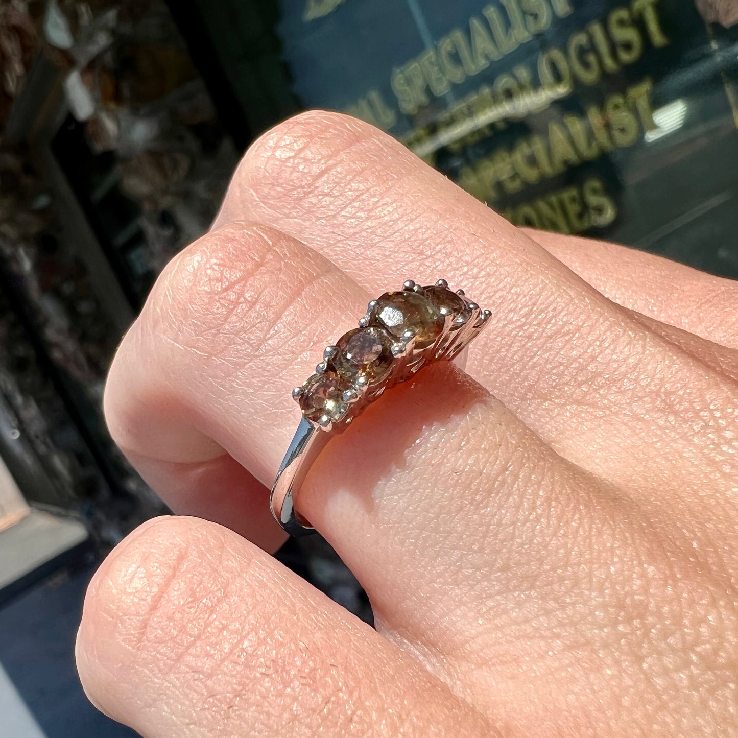 A sterling silver stackable ring set with five faceted oval and round andalusite stones.