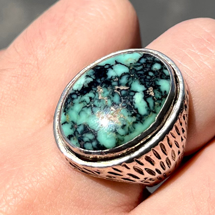 A sterling silver solitaire ring set with a black spiderweb turquoise stone from Kingman, Arizona.