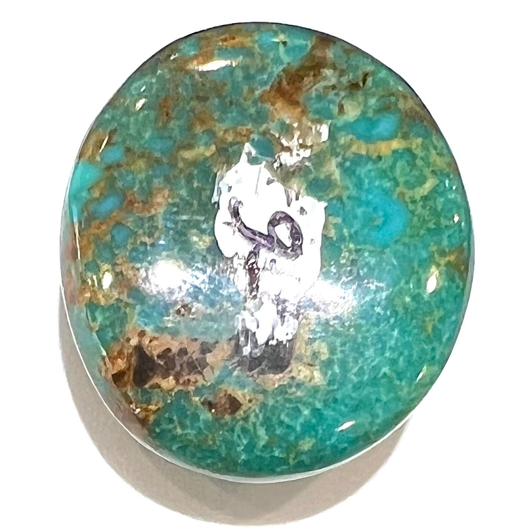 An oval cabochon cut green Royston turquoise with brown matrix.