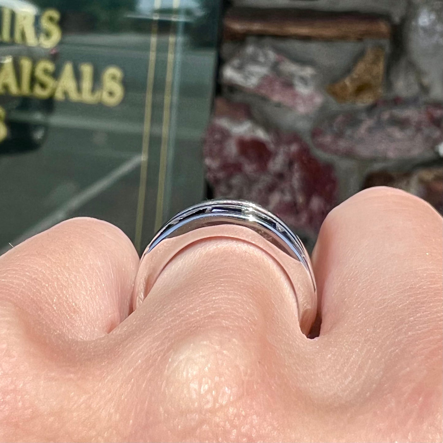A silver ring set with red, white, and blue baguette cut stones. The gallery features two stars.
