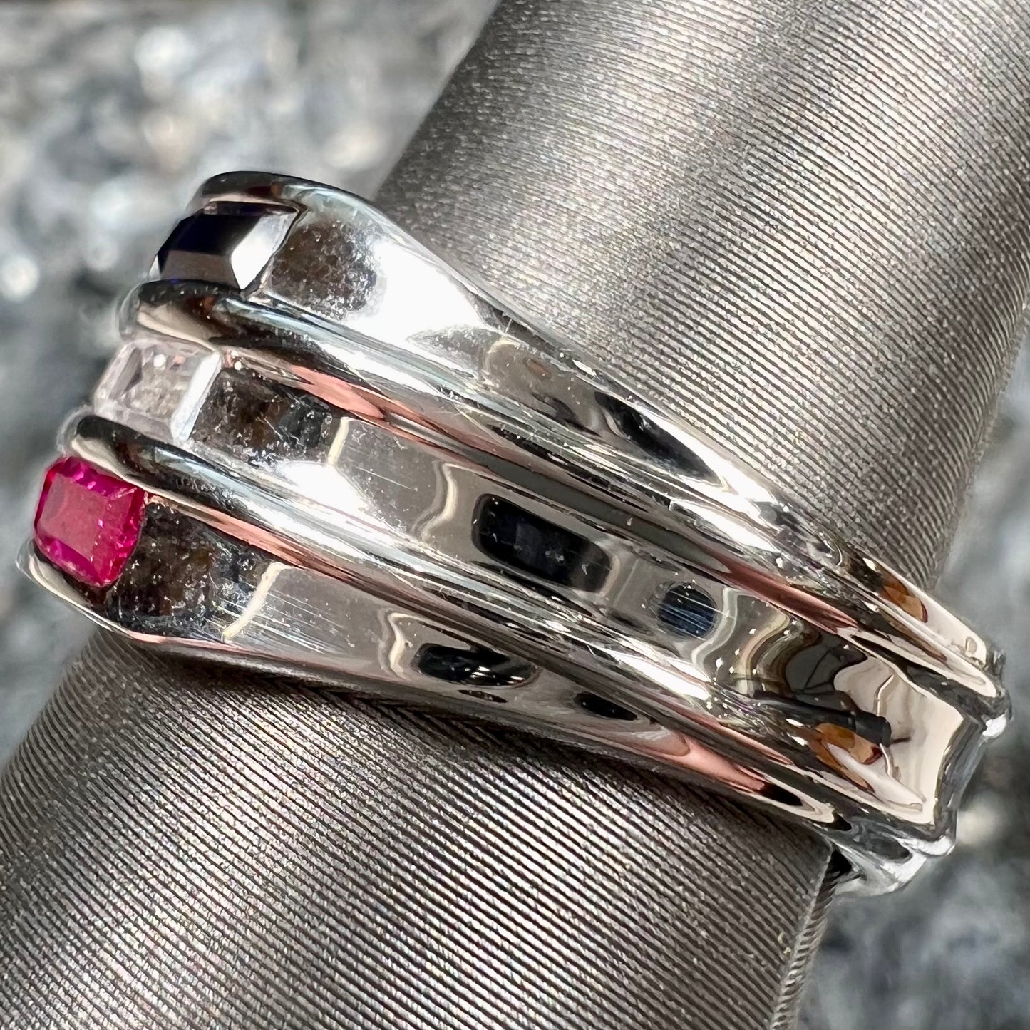 A silver ring set with red, white, and blue baguette cut stones. The gallery features two stars.